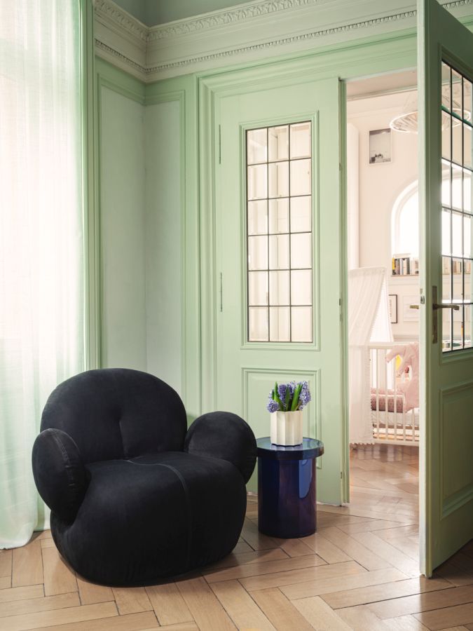 Schwarzer Nana Love Seat Sessel von Freifrau Manufaktur in stilvollem, hellgrünem Raum mit Holzboden.