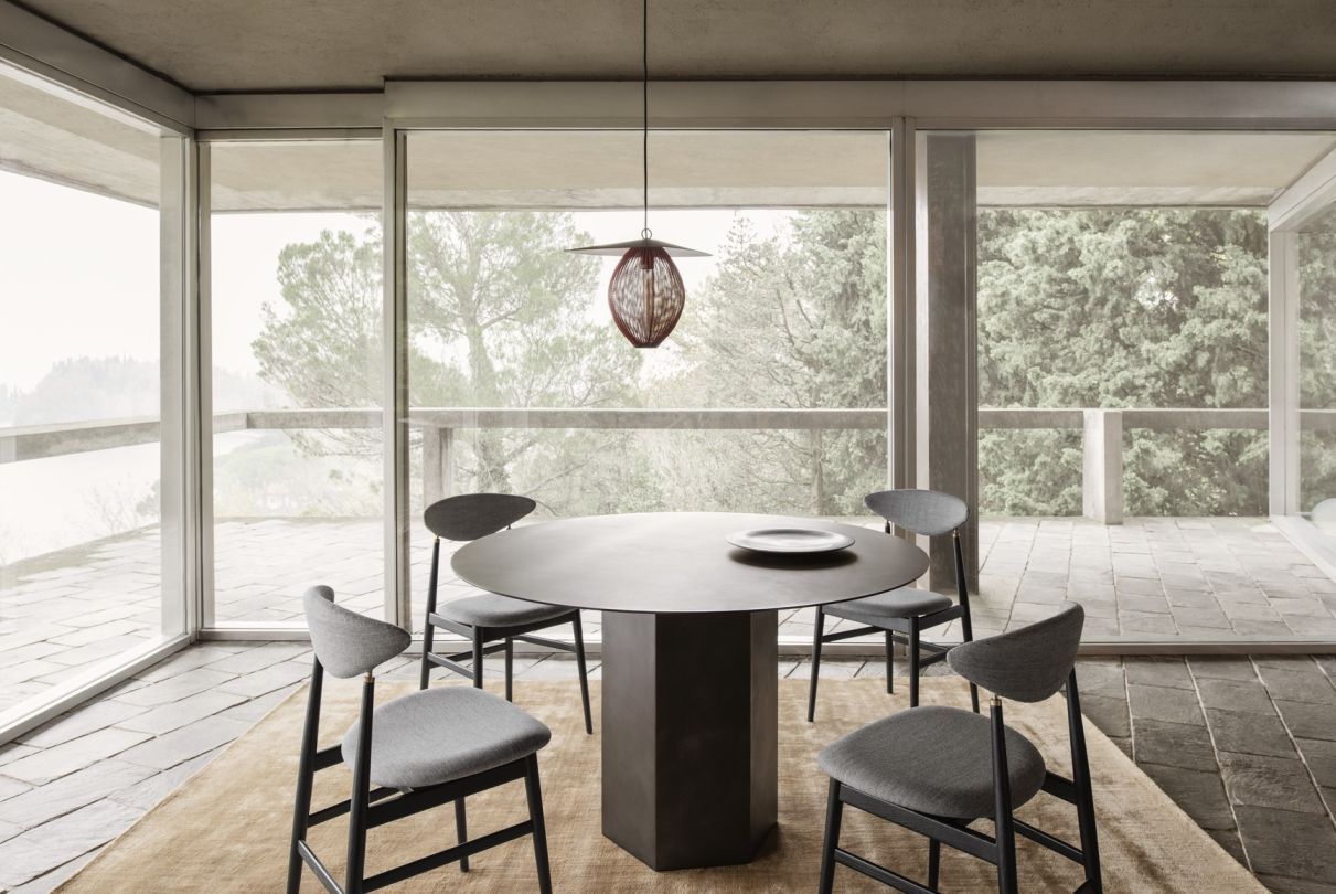 Runder Esstisch aus Stahl von Gubi, umgeben von Stühlen in einem hellen Raum.