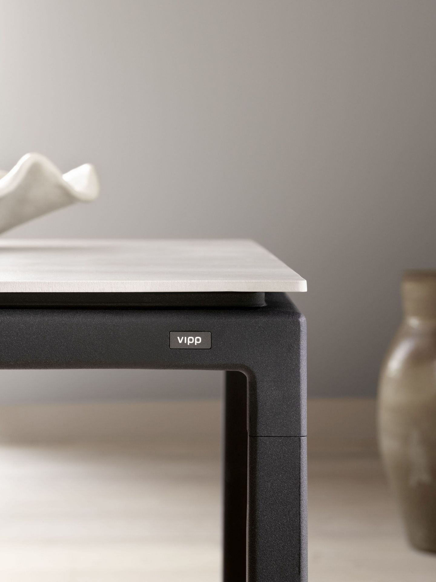 Detailaufnahme des Vipp Tisch Medium mit heller Tischplatte und schwarzem Gestell, modernes Möbeldesign.