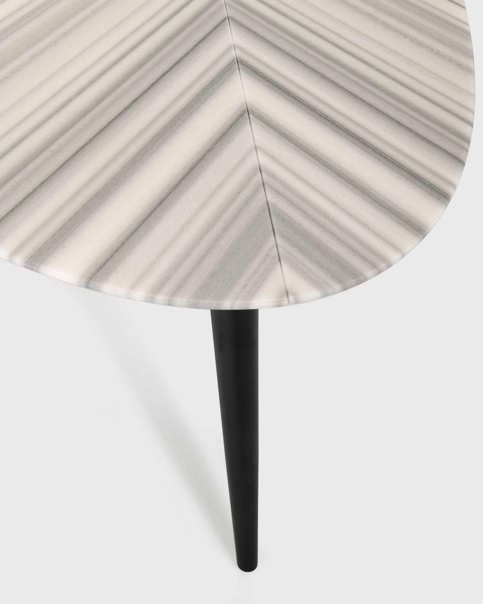 Detailaufnahme des Zanotta 2318 Tweed Marble Esstischs mit Marmorplatte und schwarzen Beinen.