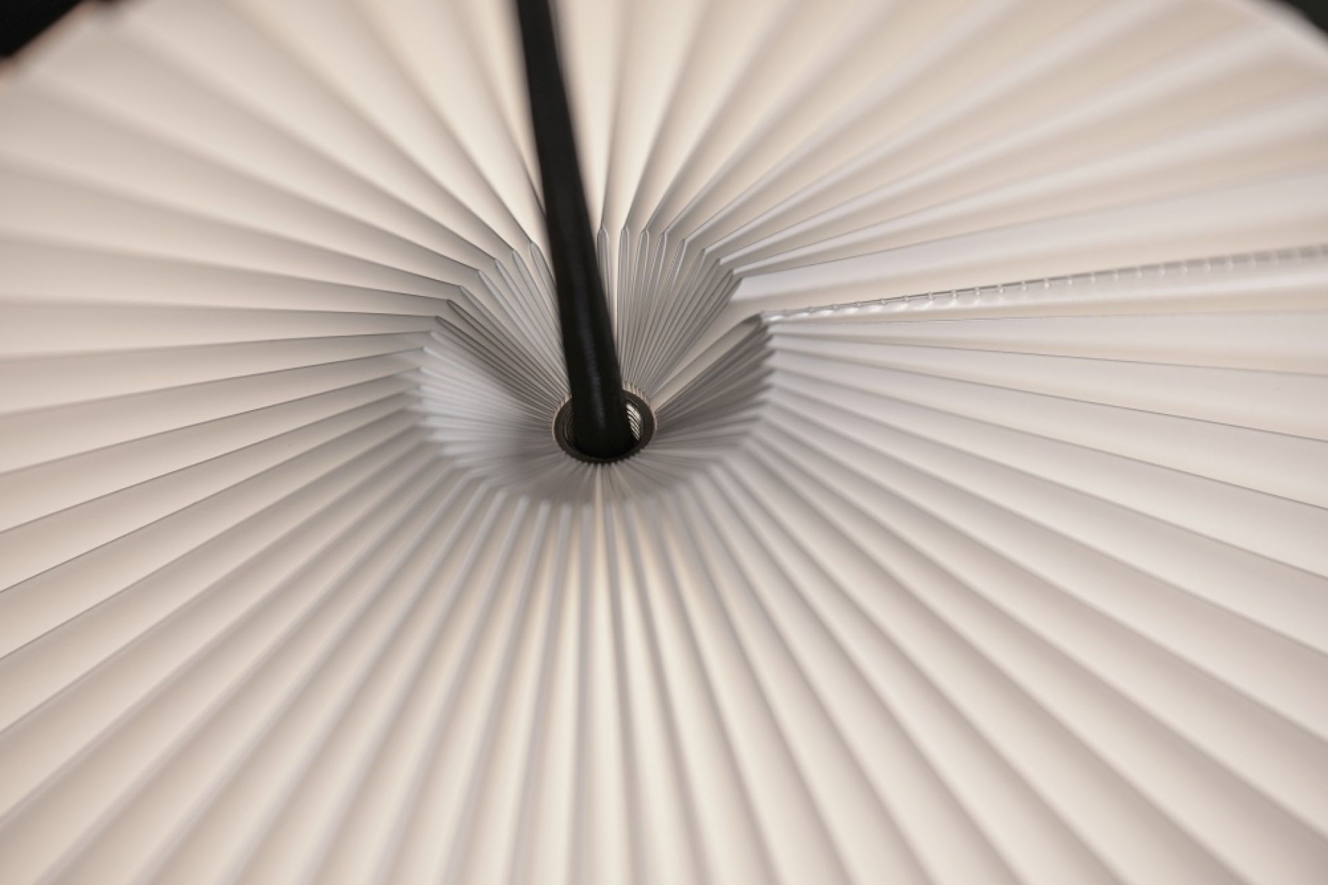 Detailaufnahme der Shibui Pendelleuchte von Le Klint mit plissiertem Lampenschirm und schwarzer Aufhängung.