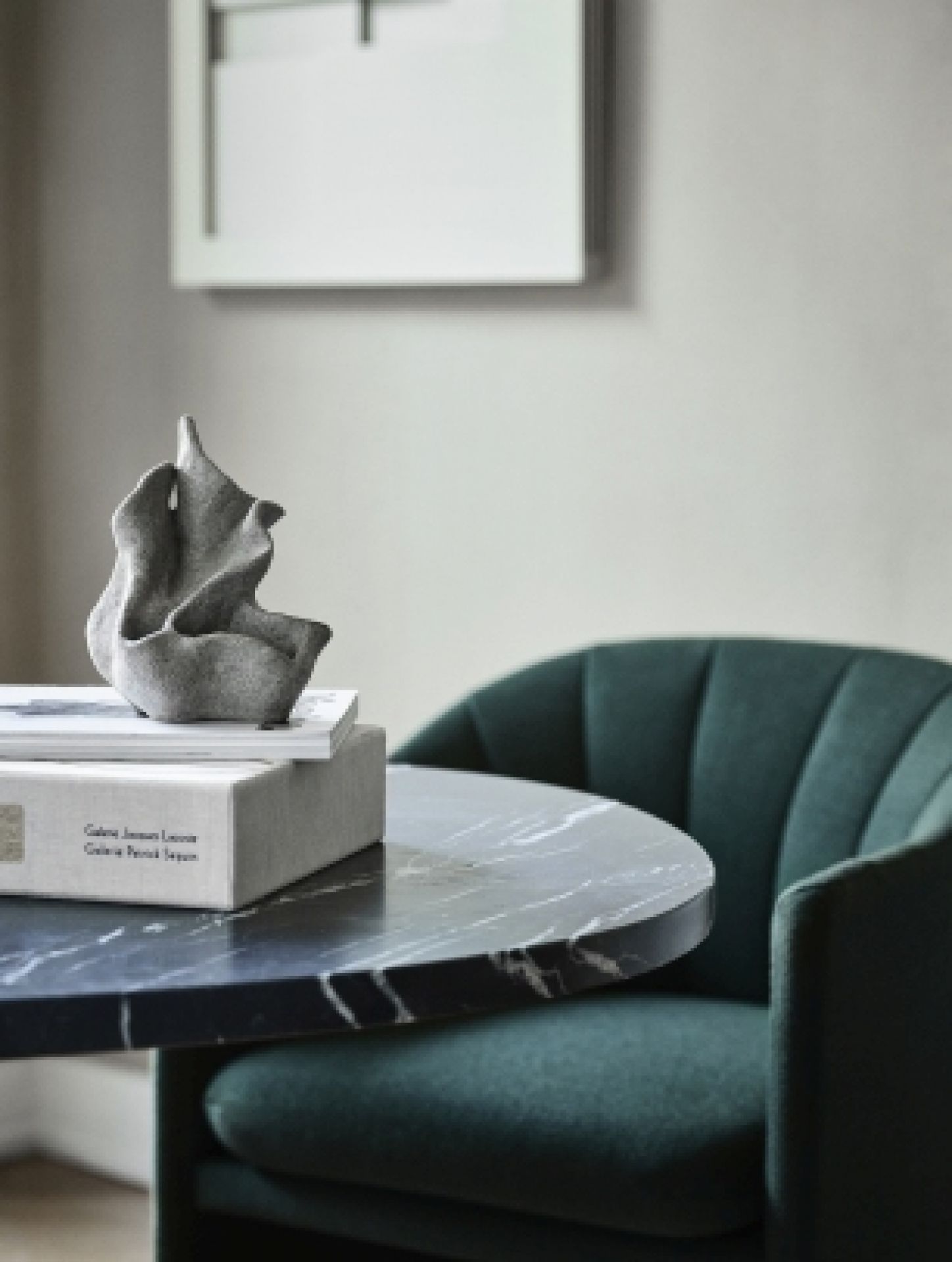Detailaufnahme: Grüner Loafer Sessel von AndTradition mit Marmortisch und Deko-Objekt. Design Sessel für Wohnzimmer.