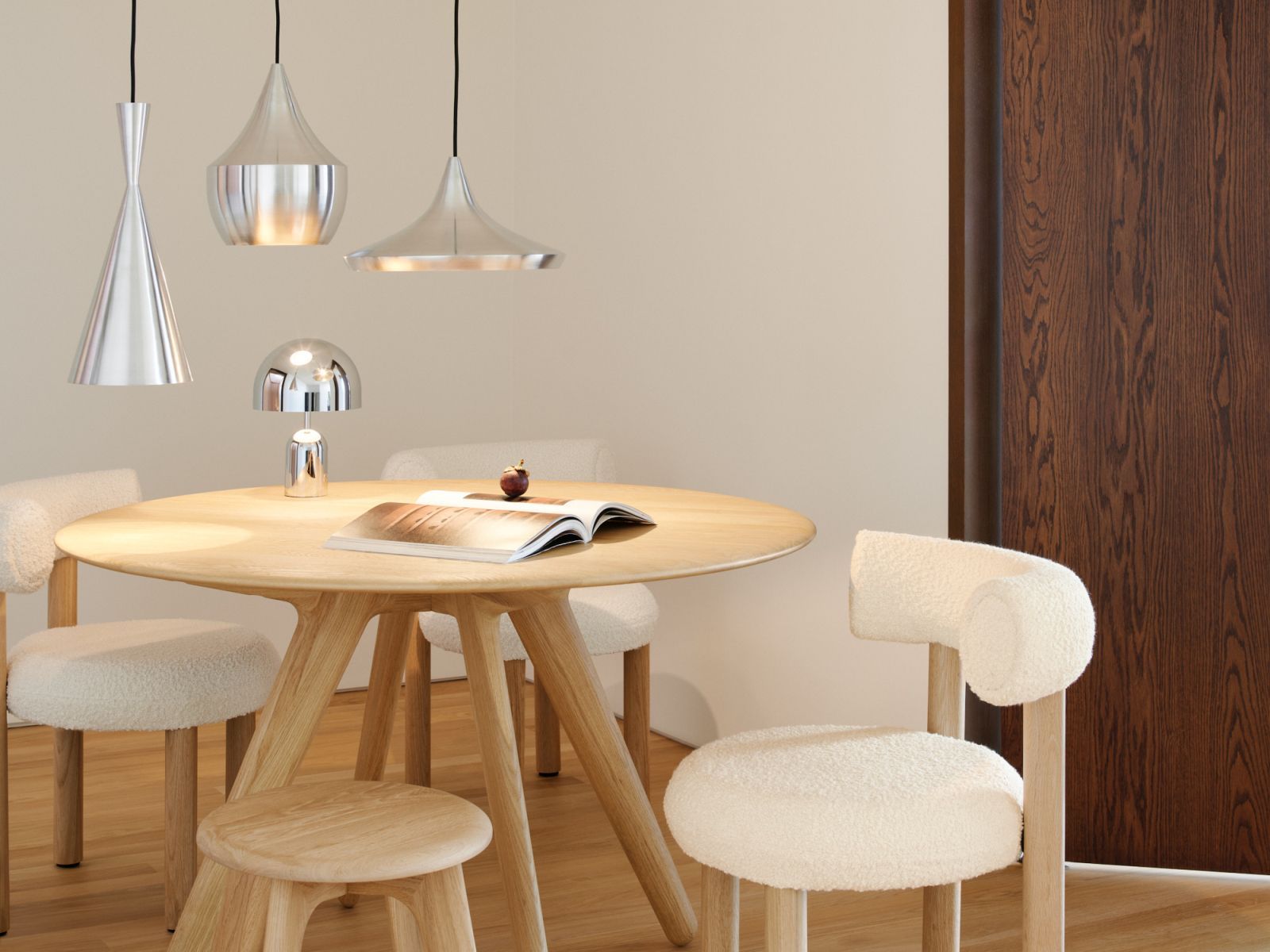 Esszimmer mit Holztisch, Stühlen und drei silbernen Unbeaten Pendelleuchten von Tom Dixon.