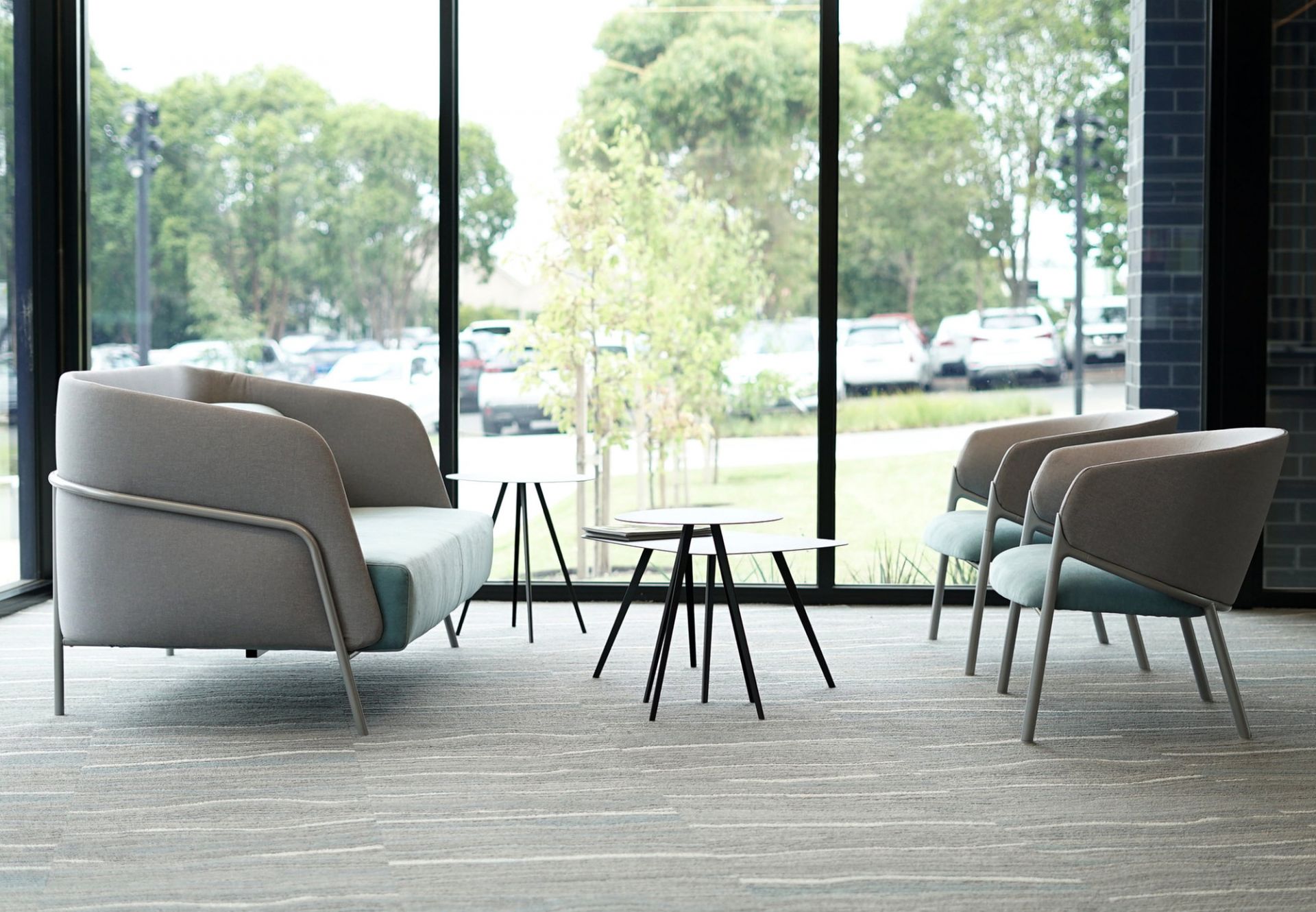 Innenaufnahme mit Agorà Beistelltischen und Stühlen, modernes Design für Wohn- und Bürobereiche.