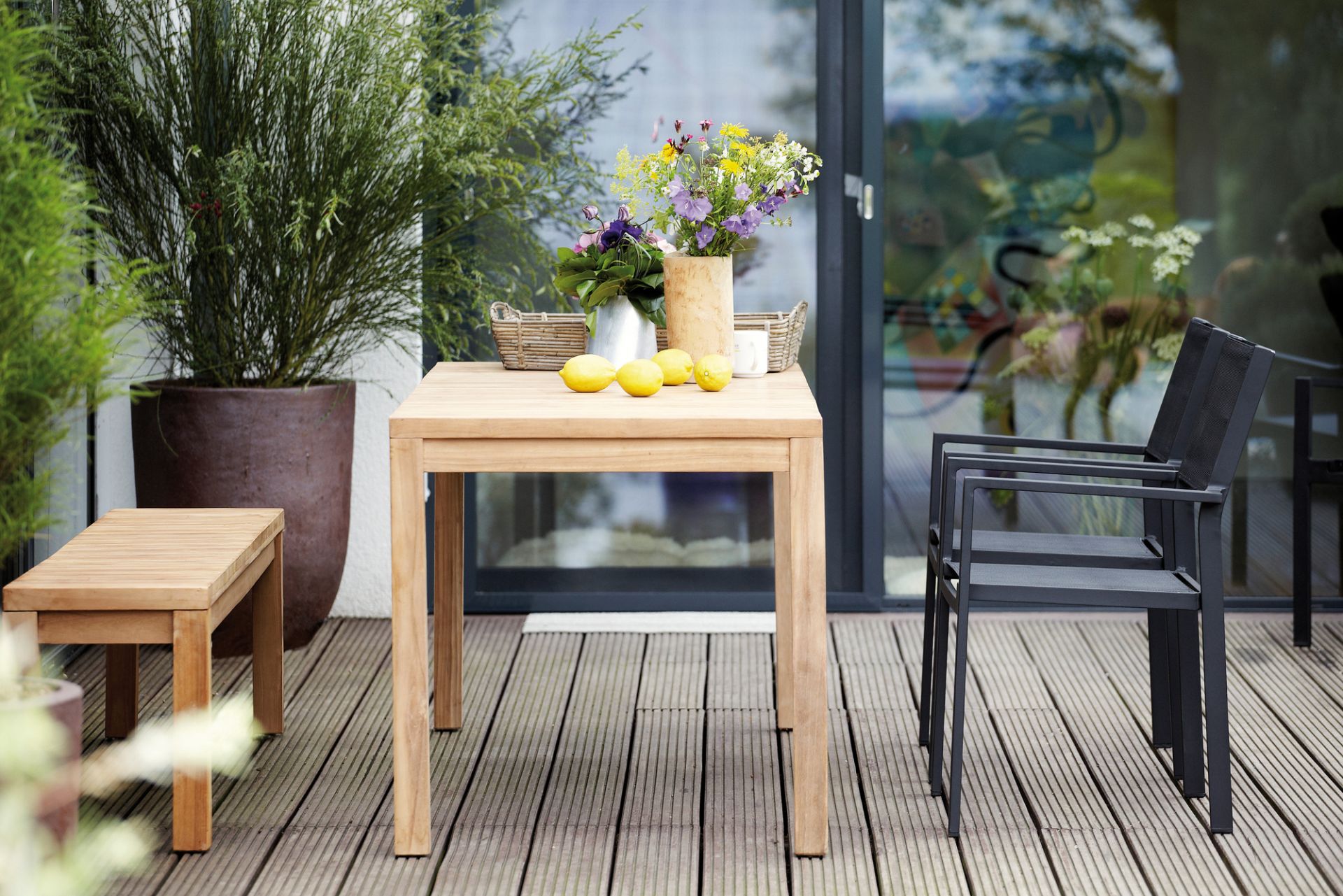 Samoa Tisch Natur von Jan Kurtz, Breite 75 cm, aus Teakholz auf einer Terrasse.