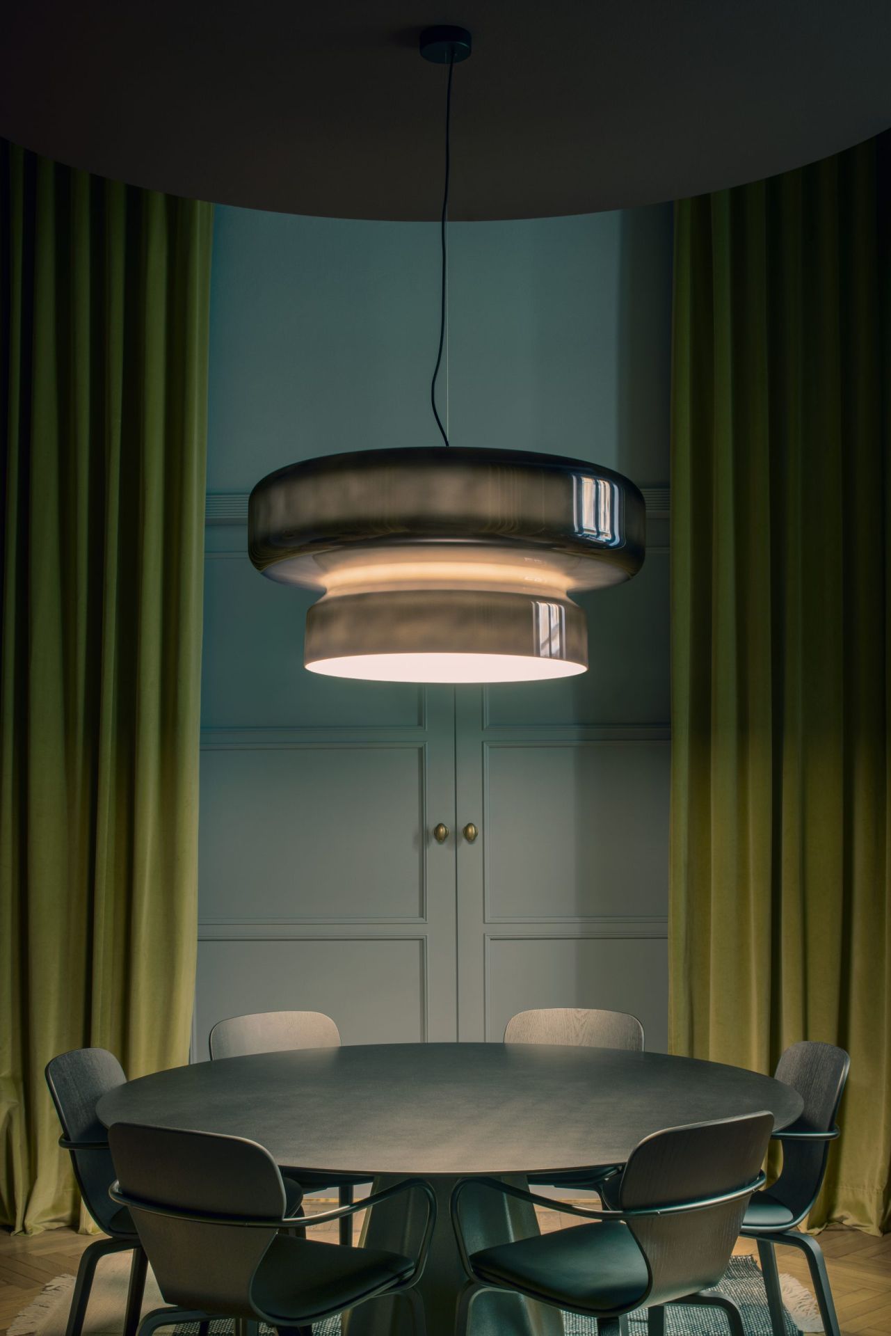Bohemia Pendelleuchte von Marset in Rauchgrau über Esstisch mit Stühlen. Designlampe.