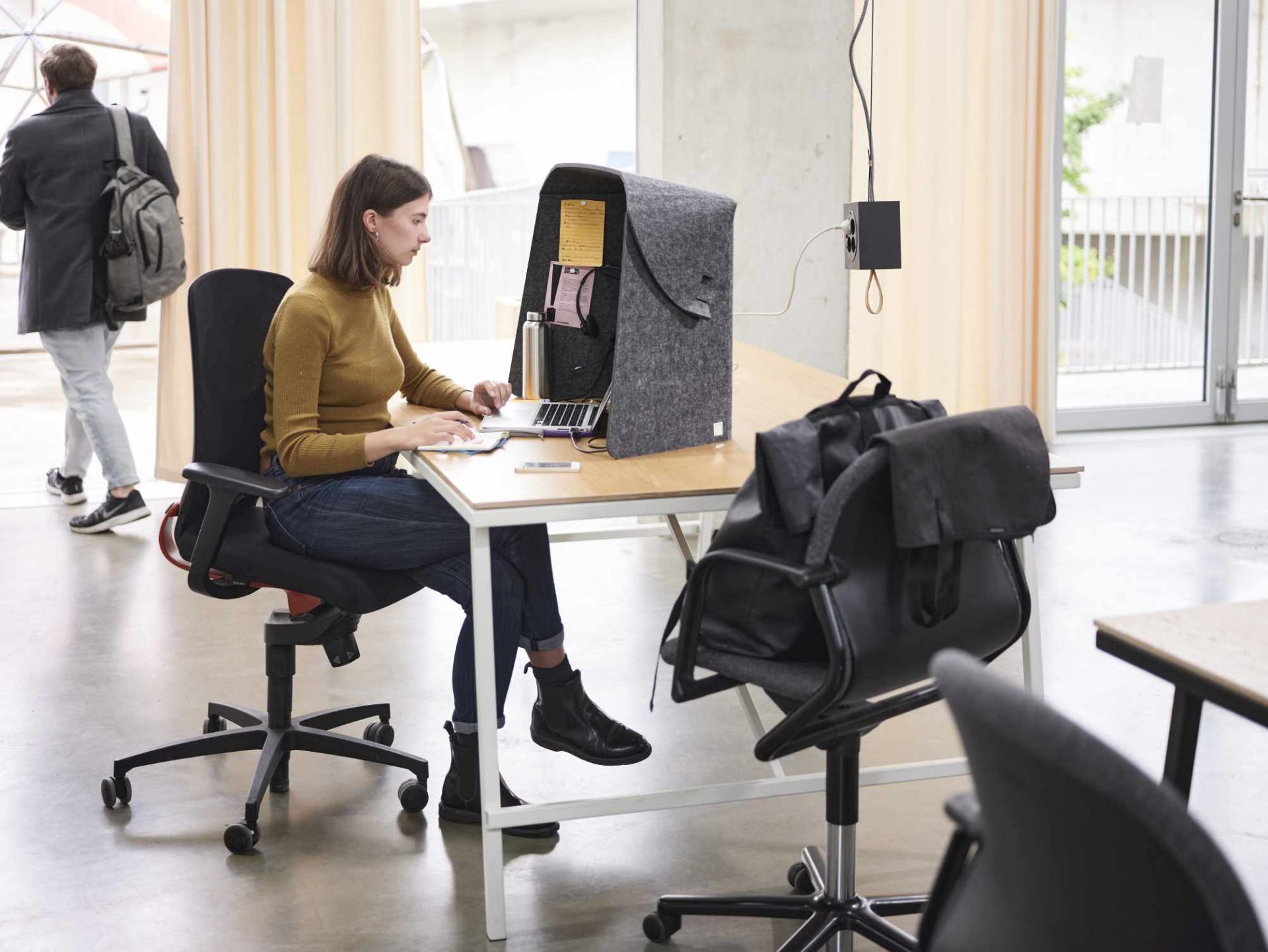 Frau arbeitet am Laptop mit dem Wilkhahn Fold-Up-Workspace für konzentriertes, mobiles Arbeiten.