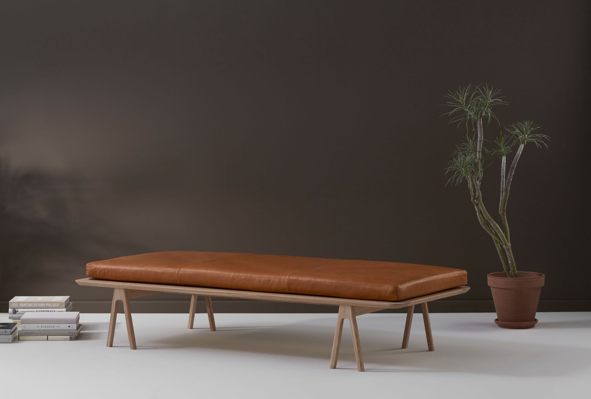 Level Daybed Liege von Woud mit braunem Lederkissen und hellem Holzgestell.
