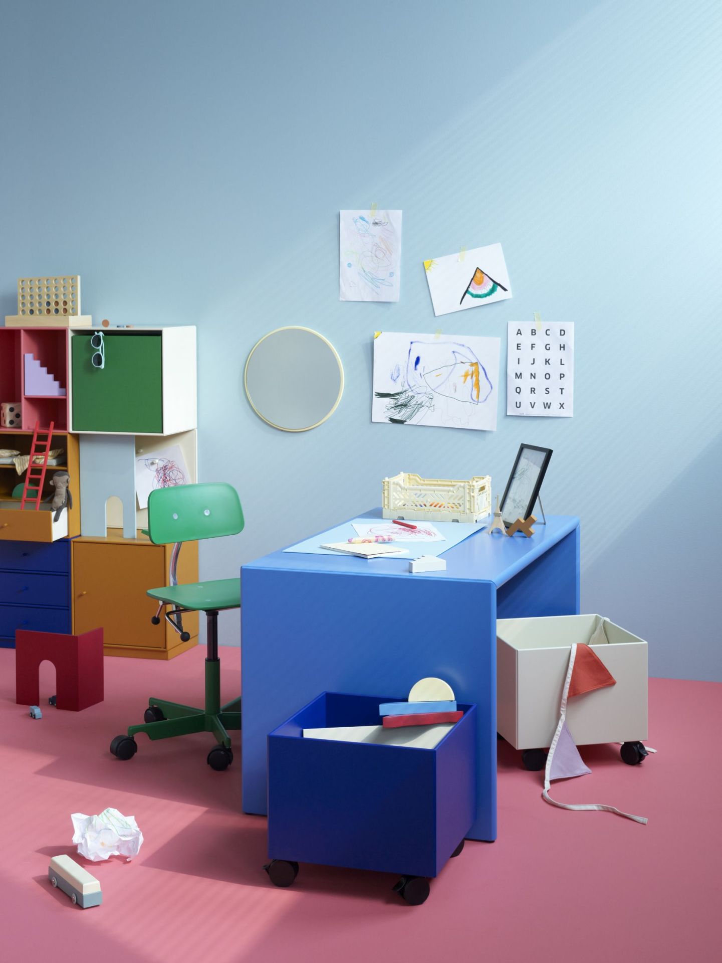 Kreatives Kinderzimmer mit blauem Schreibtisch und grünem Kevi Kids Drehstuhl. Kindermöbel und Dekoration.