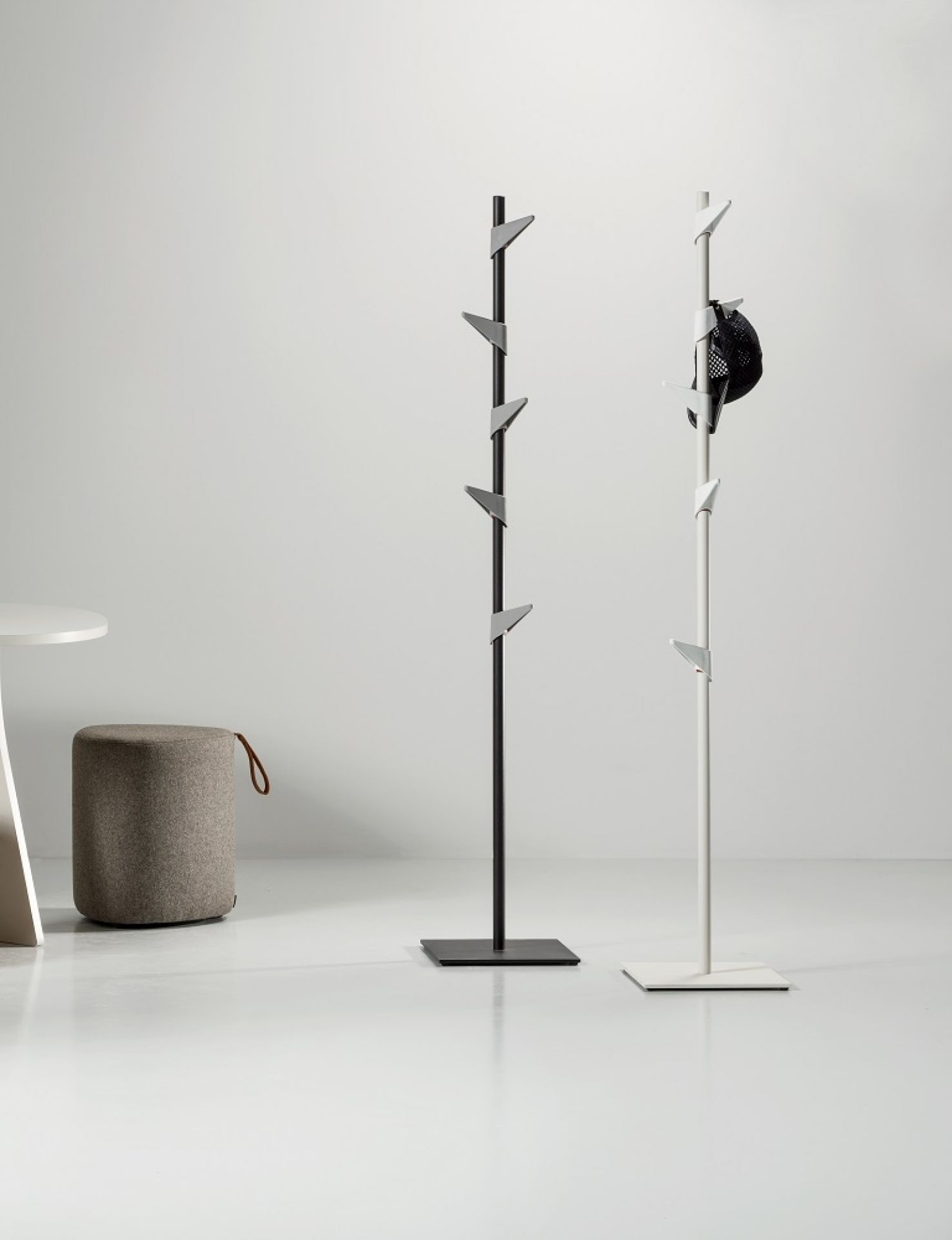 Zwei Cascando Standgarderoben: Eine schwarze und eine weiße Garderobe mit Haken für Jacken und Hüte.