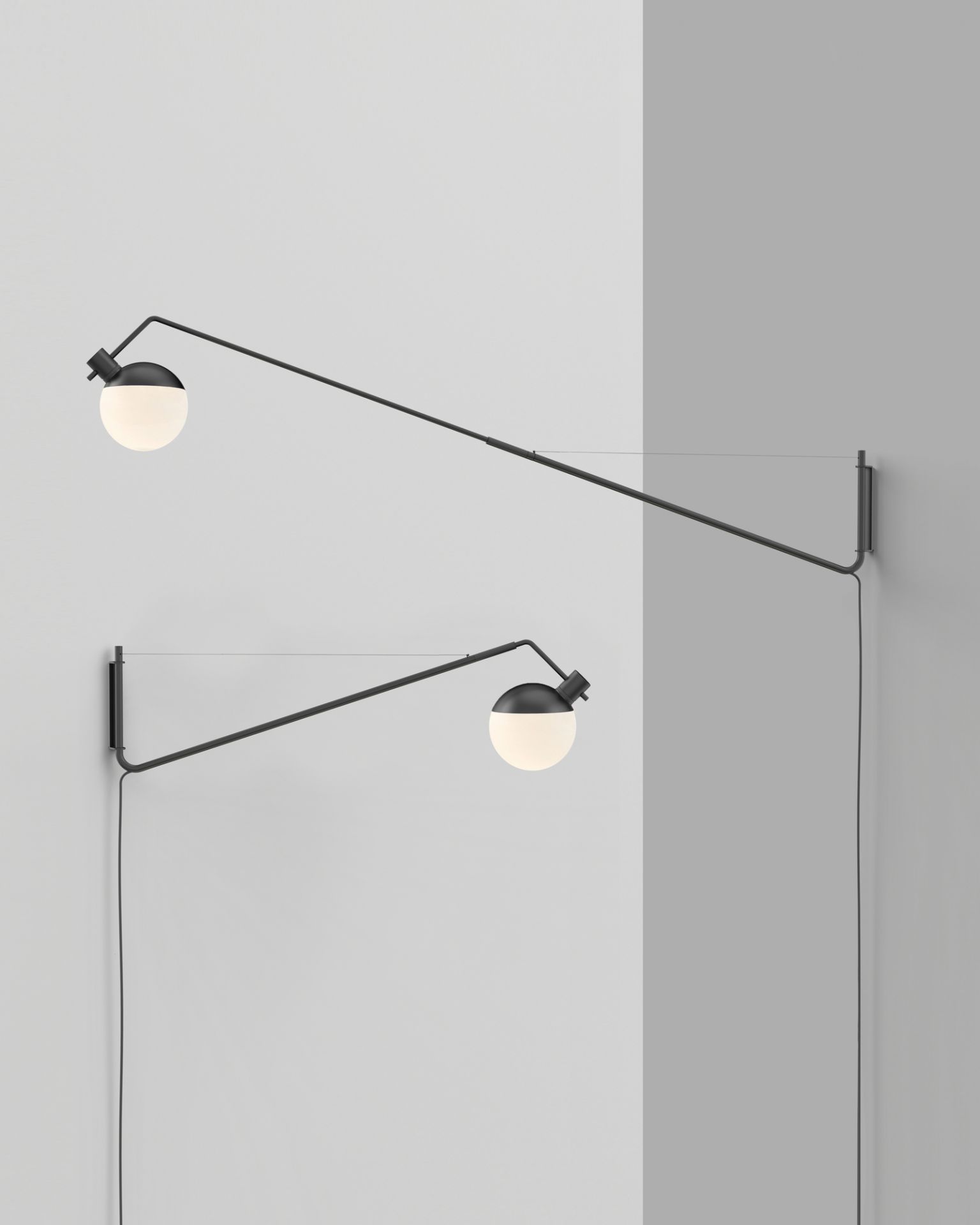 Zwei Baluna Wandleuchten von Grupa, schwarzes Metall mit runden, weißen Lampenschirmen an einer weißen Wand.