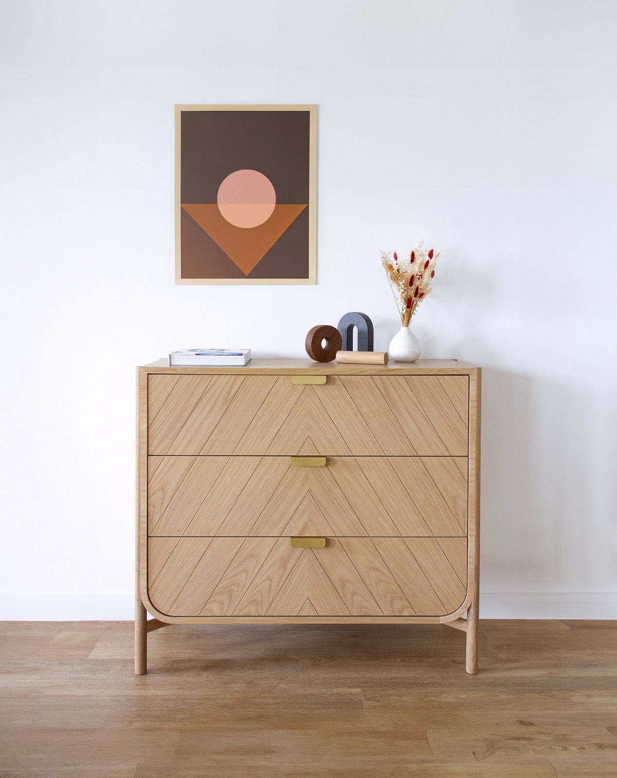 Marius Kommode von Hartô aus Eiche natur mit drei Schubladen und goldenen Griffen.