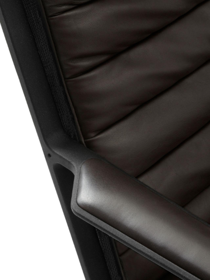 Detailaufnahme des Vipp Lounge Stuhls: Braunes Leder, gesteppte Polsterung und schwarzes Gestell.