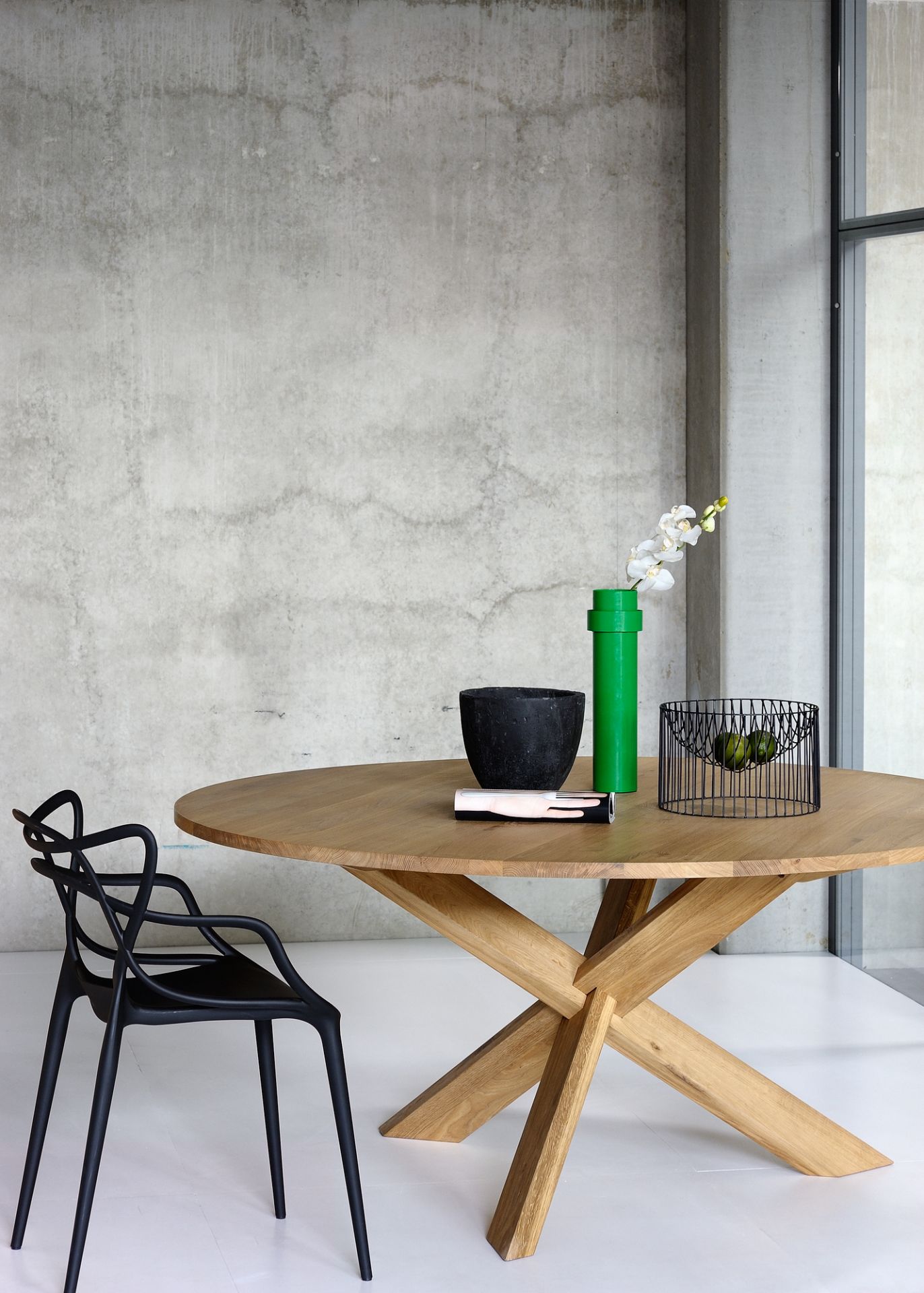 Esstisch Circle Eiche Ethnicraft: Runder Holztisch mit modernem Design und dekorativen Elementen im Esszimmer.