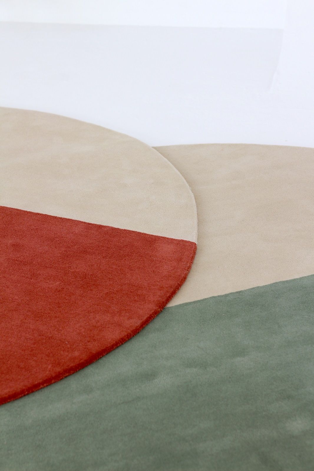 Detailaufnahme: Pearls Teppich / Wollteppich Nanimarquina mit Farbblöcken in Beige, Rot und Grün.