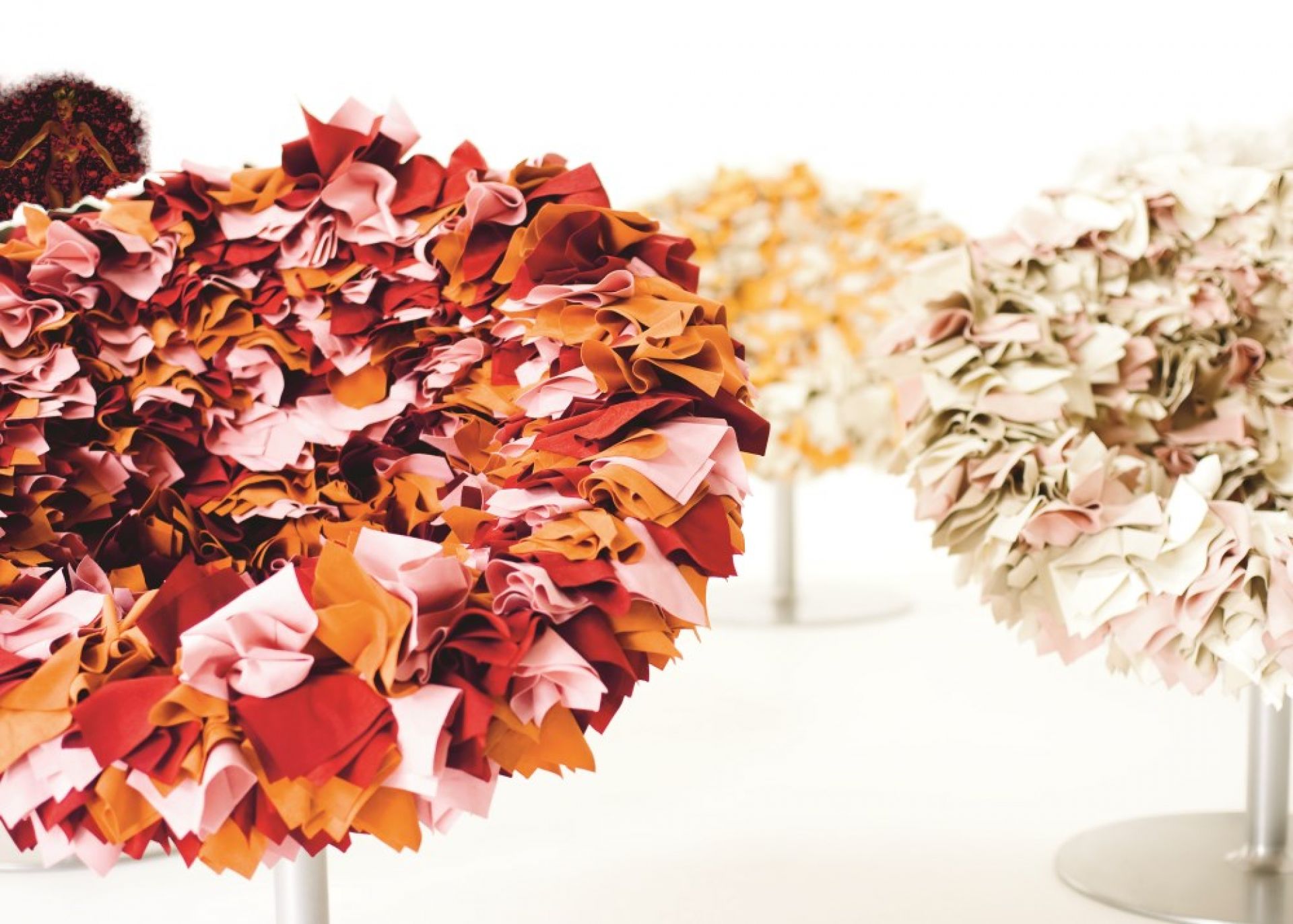 Nahaufnahme: Moroso Bouquet Sessel mit Stoffblüten in Rot-, Orange- und Rosatönen. Designermöbel für stilvolles Wohnen.