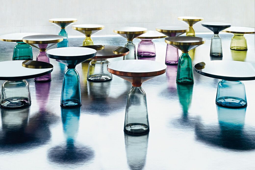 Bell Table von Classicon: Mehrere farbige Beistelltische mit Glasfuß und runder Tischplatte auf glänzendem Untergrund.