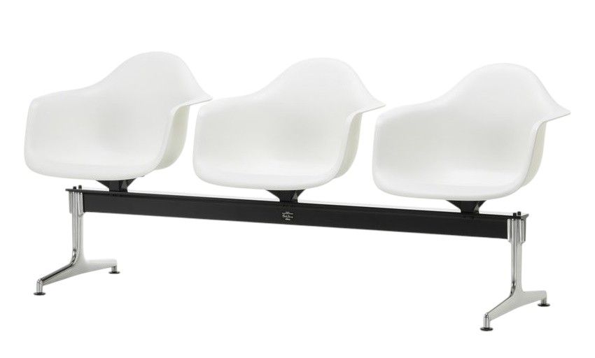 Eames Armchair auf Traverse von Vitra, weiße Kunststoffschalen auf schwarzem Gestell mit Chromfüßen.