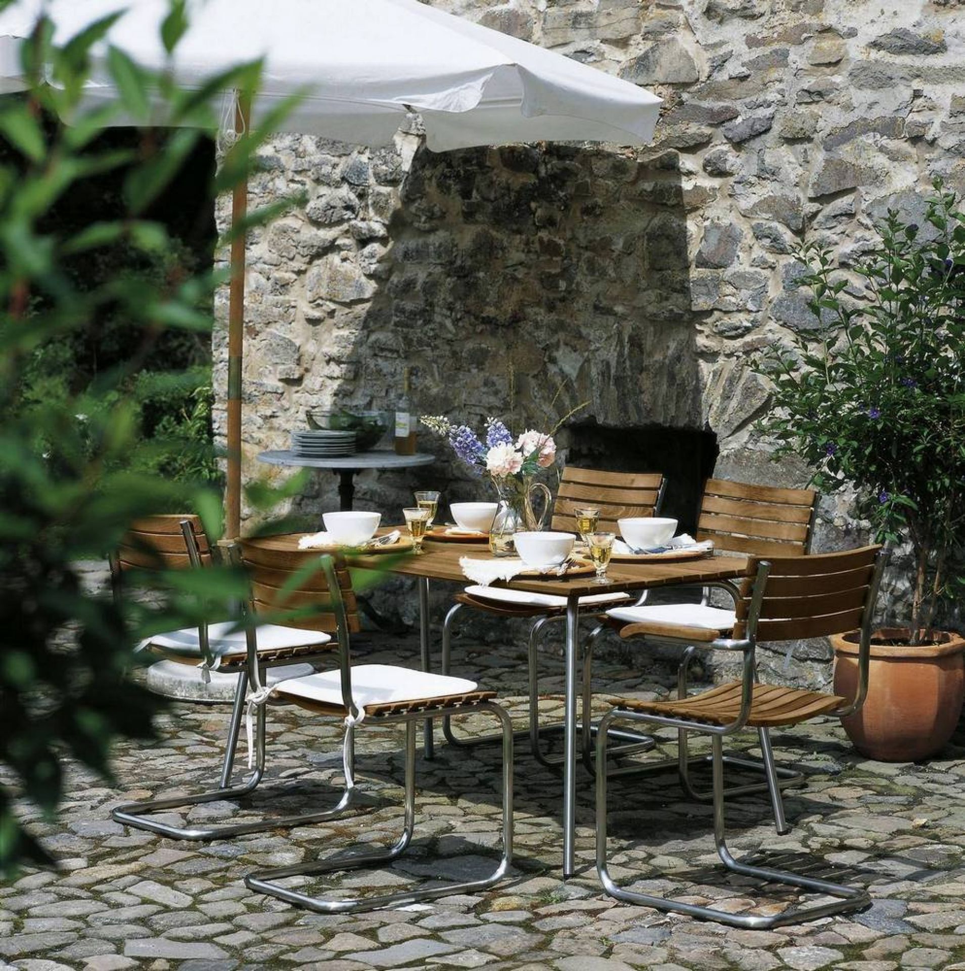 S 1040 Gartentisch von Thonet mit Stühlen im Freien, gedeckt für ein Essen.