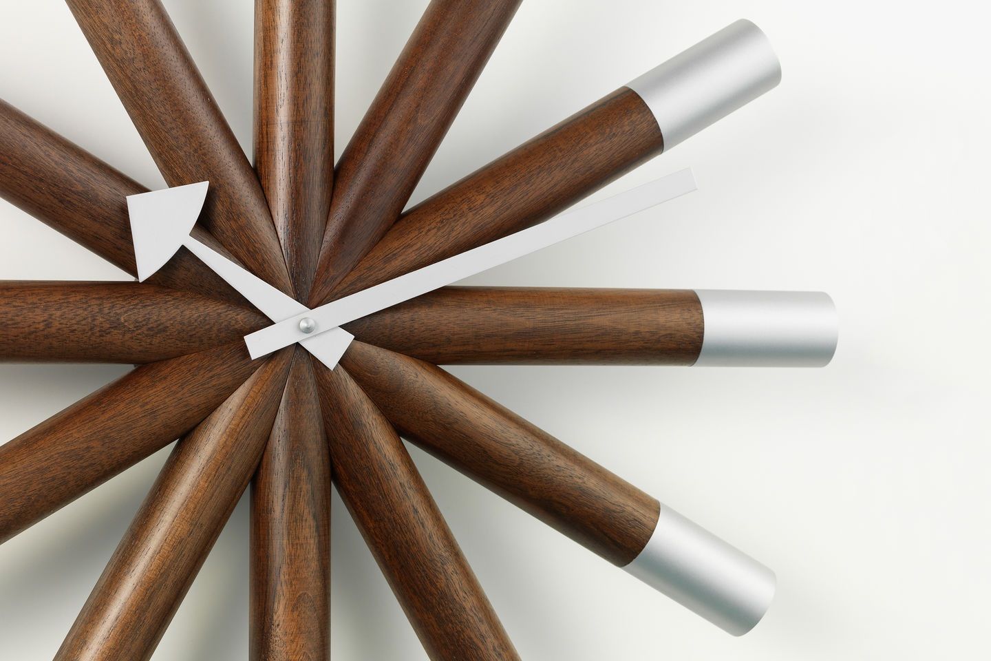 Detailaufnahme der Vitra Wheel Clock Wanduhr mit Holzstrahlen und silbernen Akzenten, modernes Design für Wohnzimmer.