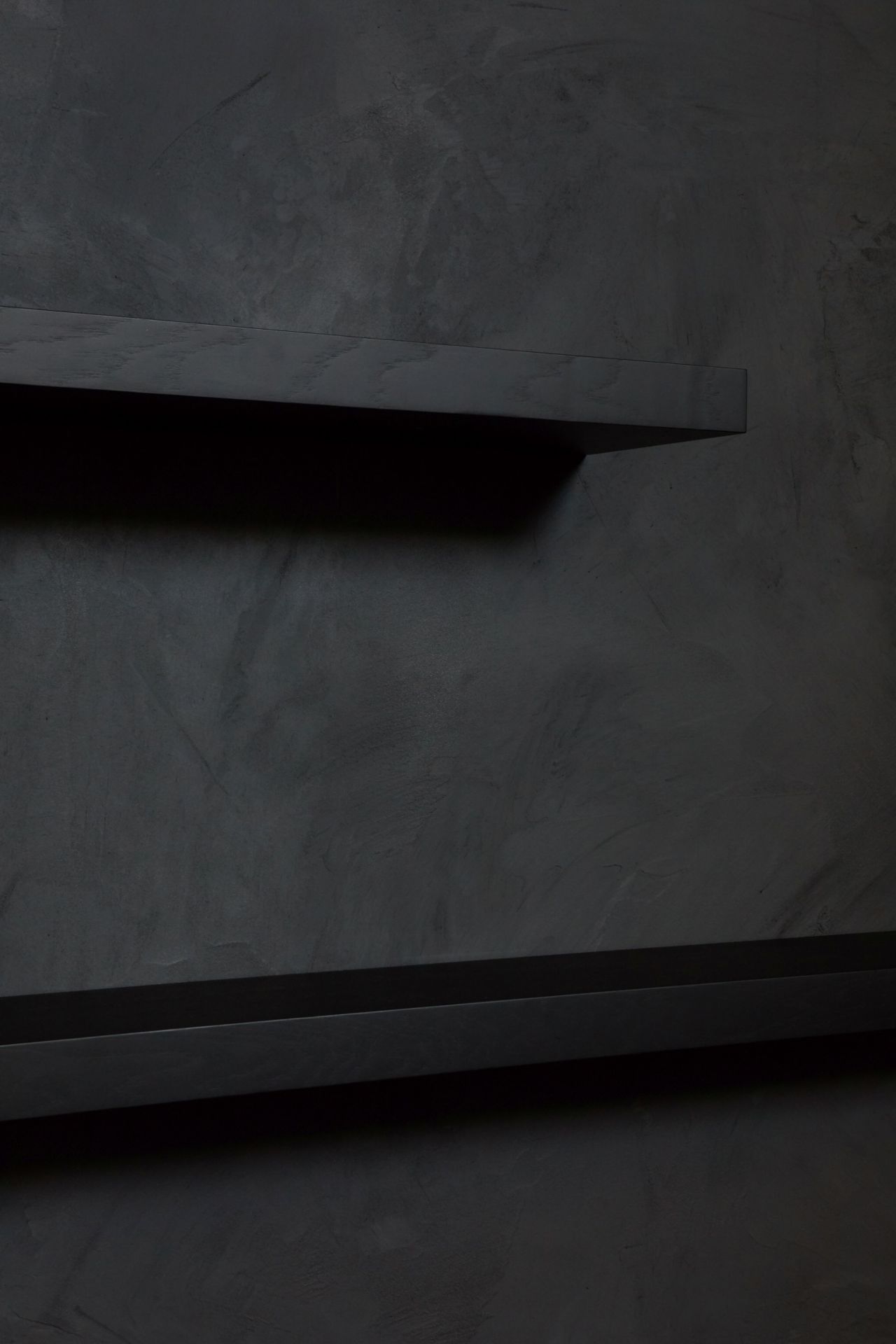 Zwei schwebende, schwarz lackierte Wandregale aus Eiche von Ethnicraft vor einer dunklen Wand.