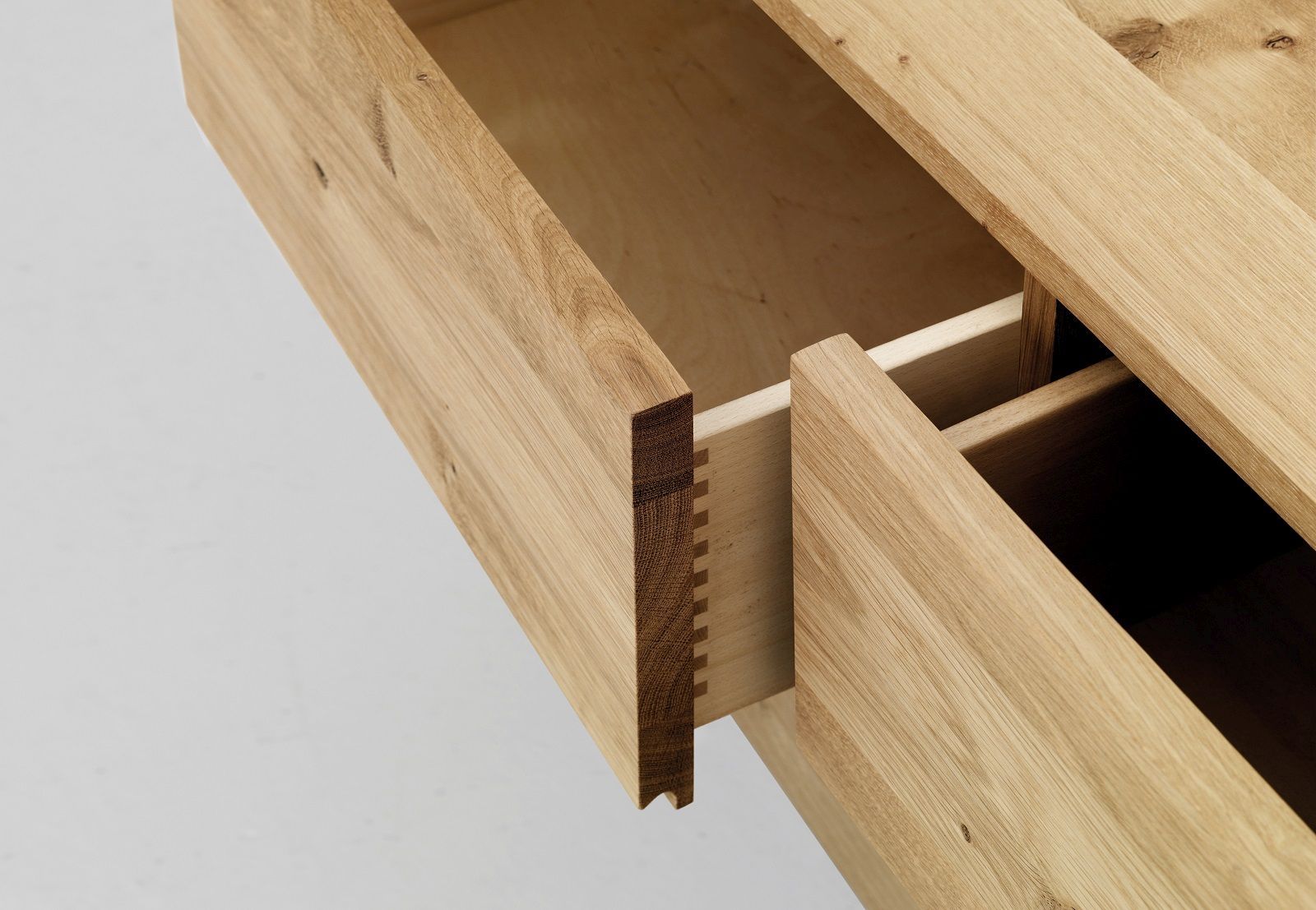 Detailaufnahme von Schubladen des Podest Sideboards aus hellem Massivholz mit offener Holzverbindung.