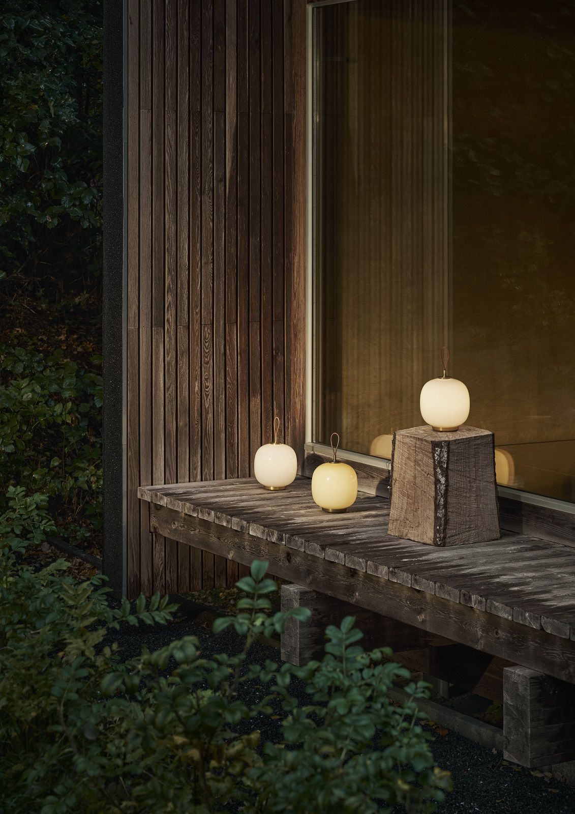 Drei VL 45 Radiohus Tischleuchten von Louis Poulsen in Weiß und Gelb auf Holzterrasse.