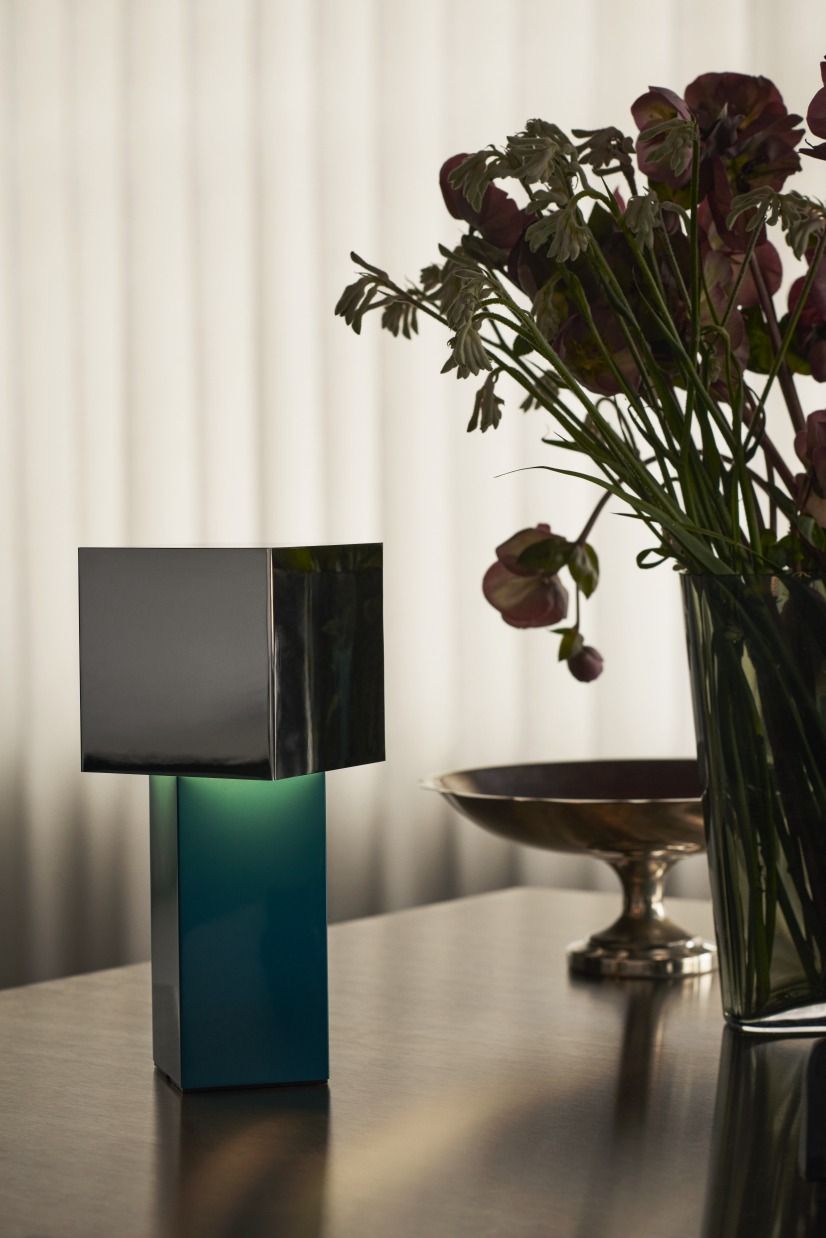 Pivot ATD7 Tischleuchte von AndTradition, moderne Akkuleuchte in Blau und Silber auf Tisch.