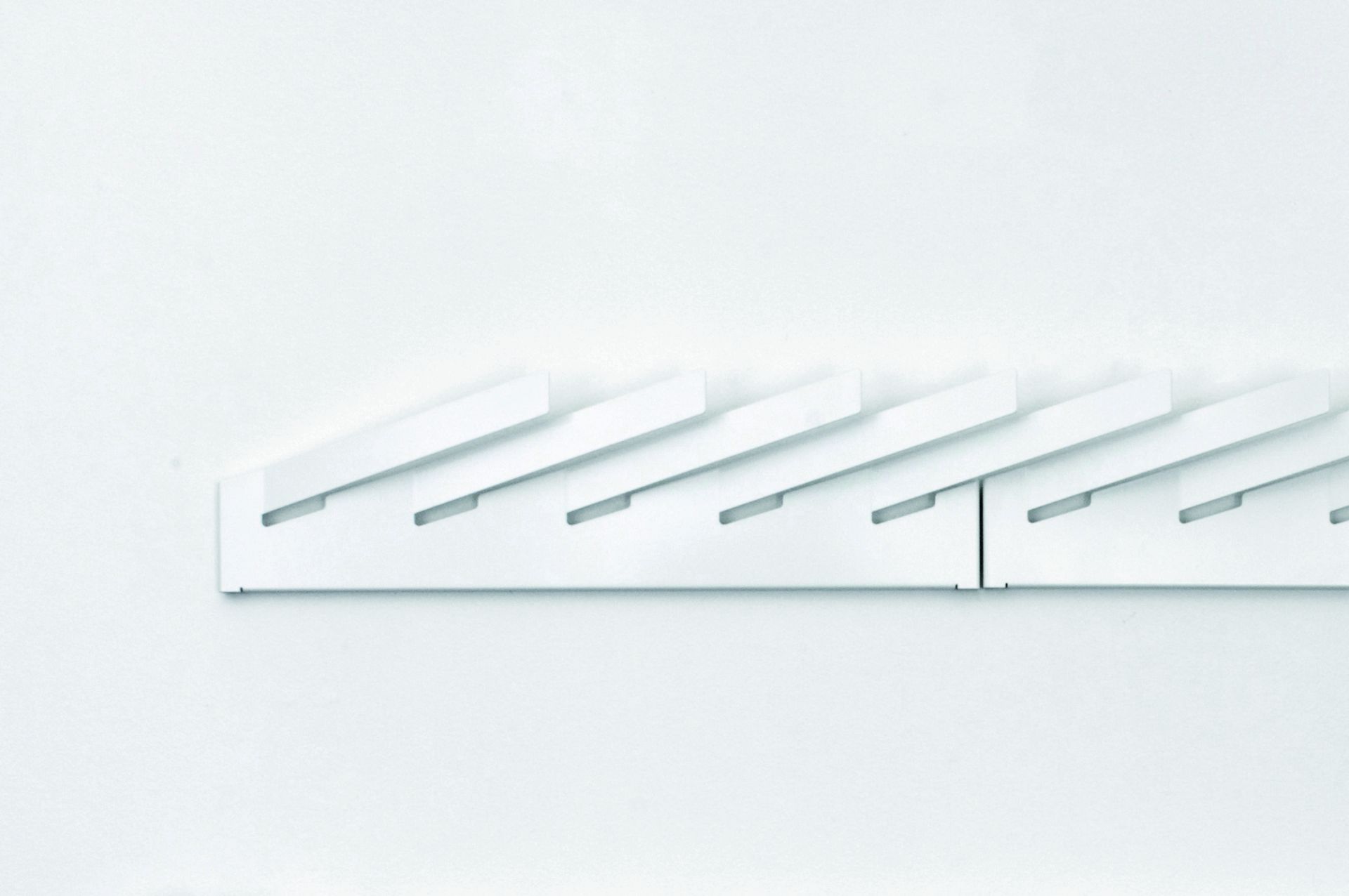 Weißer Mr_Magazinhalter Linea1 von Müller Möbelwerkstätten an einer weißen Wand. Modernes Design für Zeitschriften und Magazine.