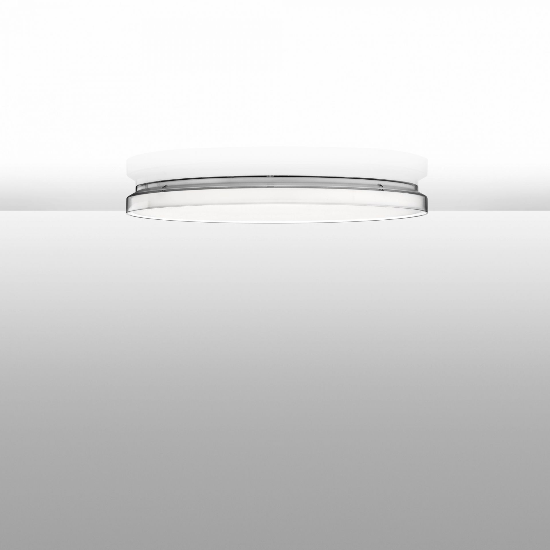 Weiße Flos Deckenleuchte Clara mit transparentem Ring, moderne Innenbeleuchtung für Wohnräume.