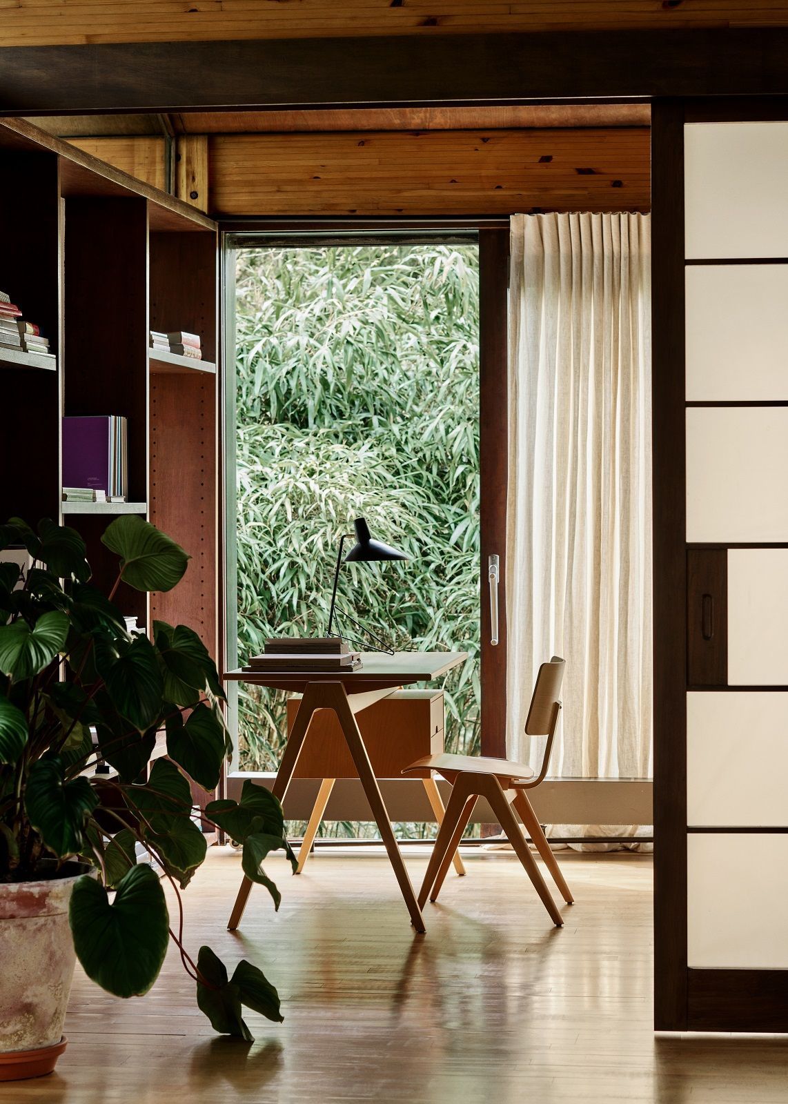 Nahaufnahme einer Tripod HM9 Tischleuchte von AndTradition auf einem Schreibtisch in einem hellen Raum.