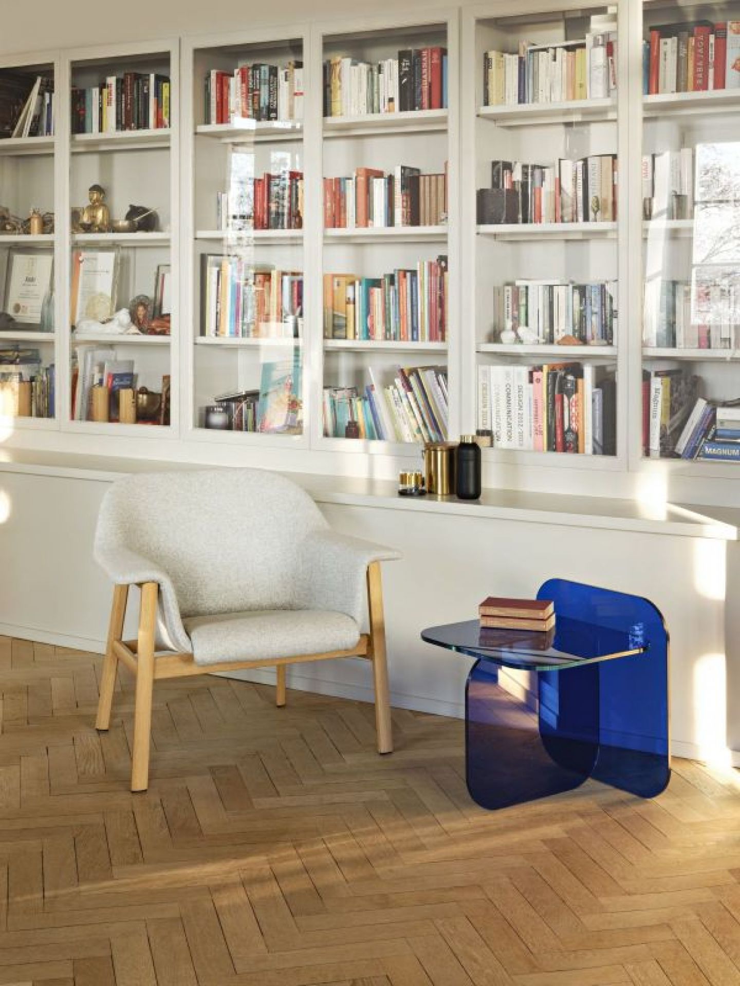 Sol Beistelltisch von ClassiCon, royalblaues Kristallglas, modernes Design, neben Sessel im Wohnzimmer.