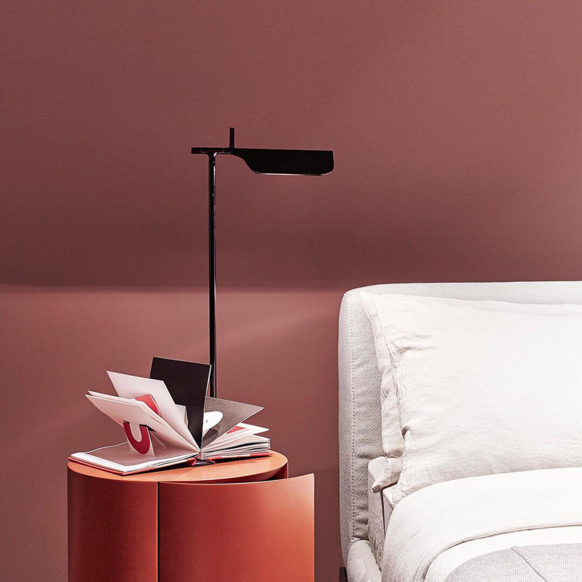 Schwarze Tab T LED Tischleuchte von Flos auf Nachttisch neben Bett, modernes Design.
