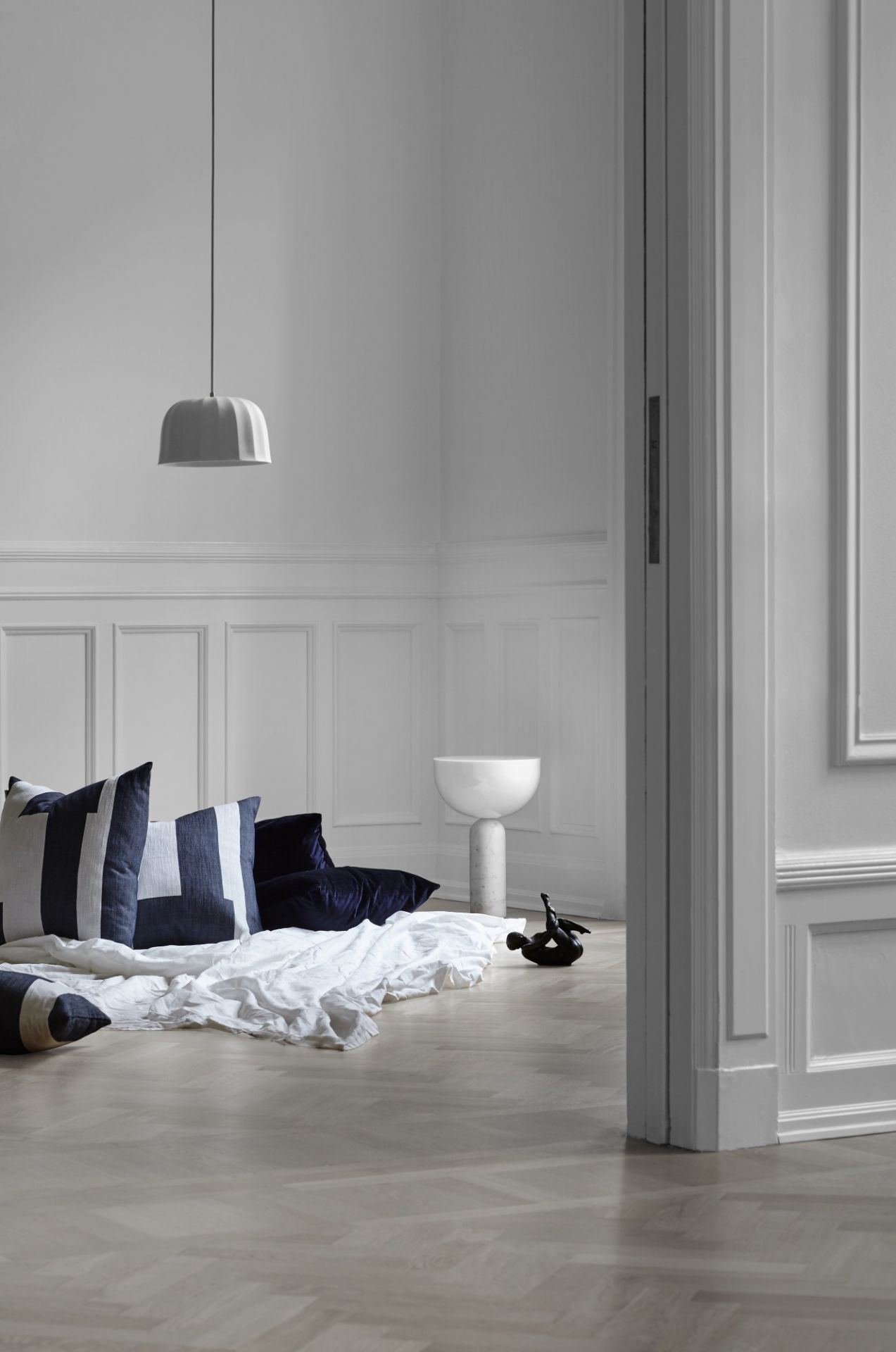 Minimalistisches Interieur mit New Works Kizu Tischleuchte und dekorativen Kissen. Moderne Beleuchtung für Wohnzimmer.