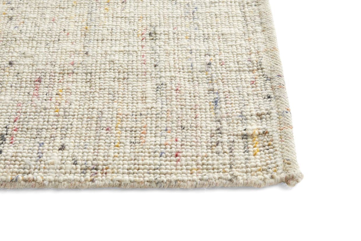 Detailaufnahme des Hay Crayon Rug Teppichs in Beige mit bunten Farbsprenkeln, gewebte Textur.