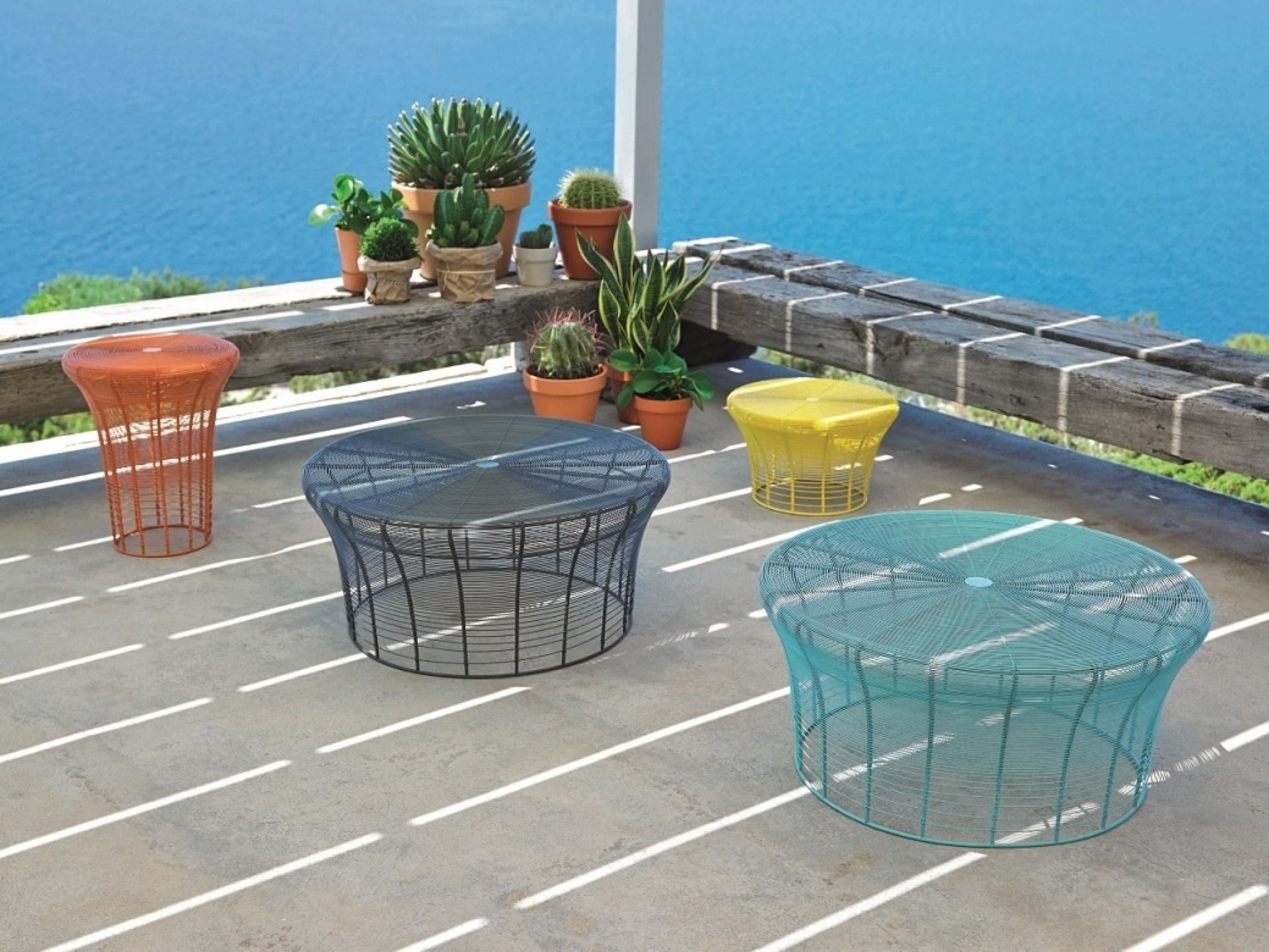 Mehrere farbige Aram Hocker von GAN auf einer Terrasse mit Meerblick. Design Hocker.