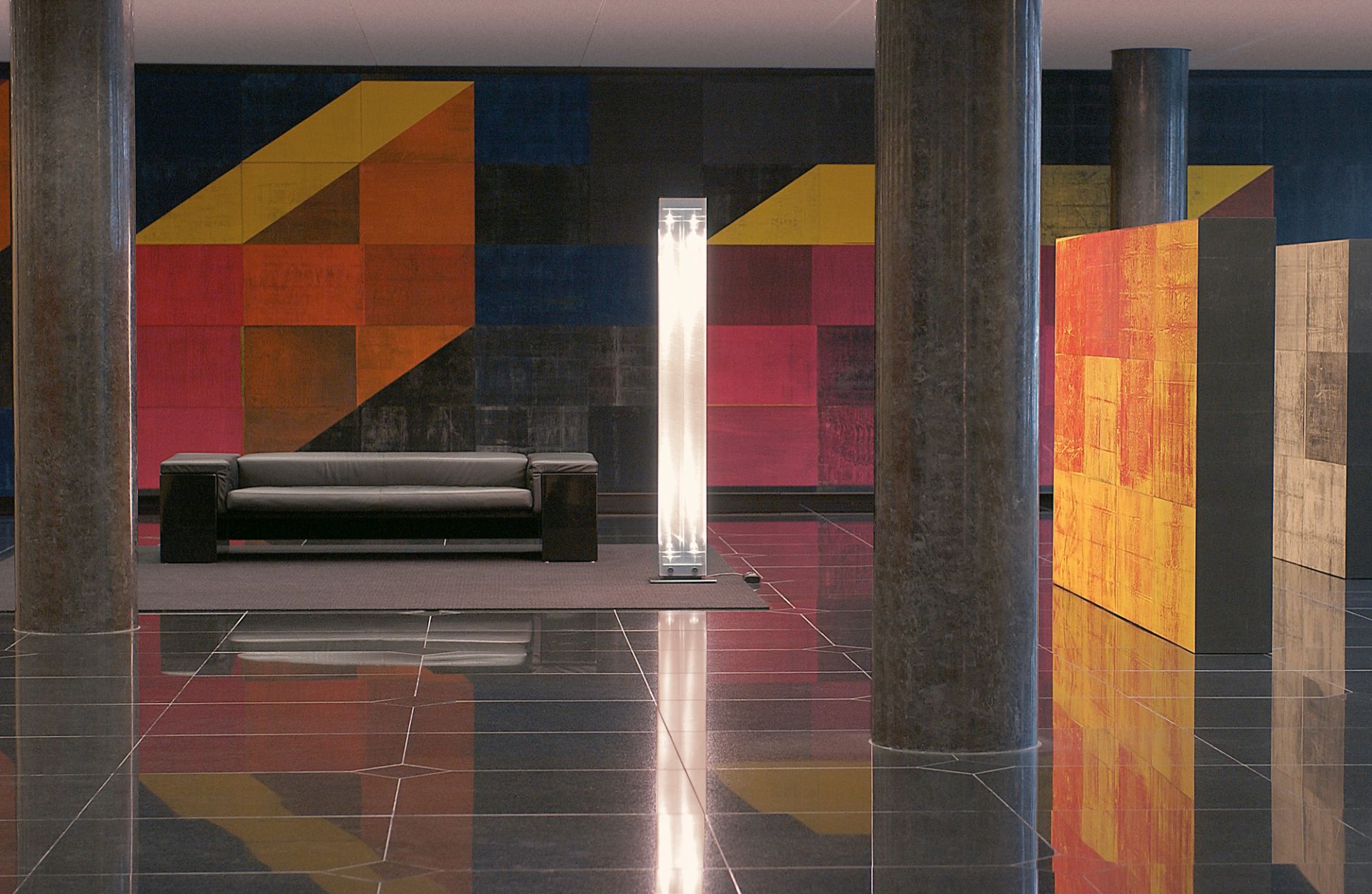 Twilight LED Stehleuchte von Belux in modernem Interieur mit Sofa und Kunstinstallation.