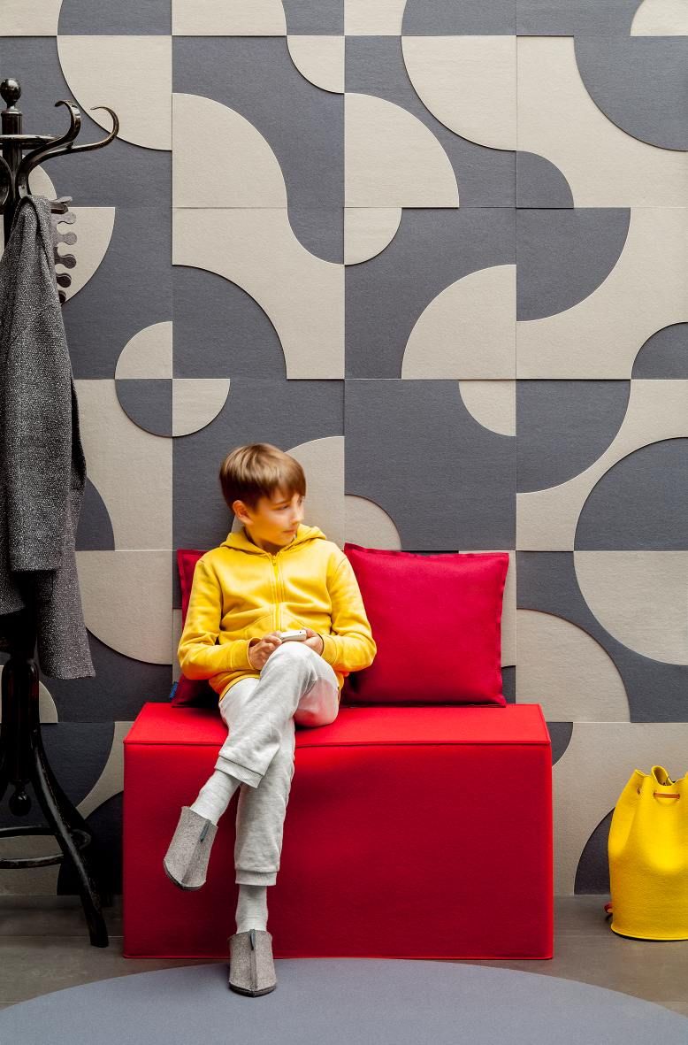 Junge sitzt auf rotem Hey Sign Quader Hocker mit Kissen, Filz Sitzmöbel.