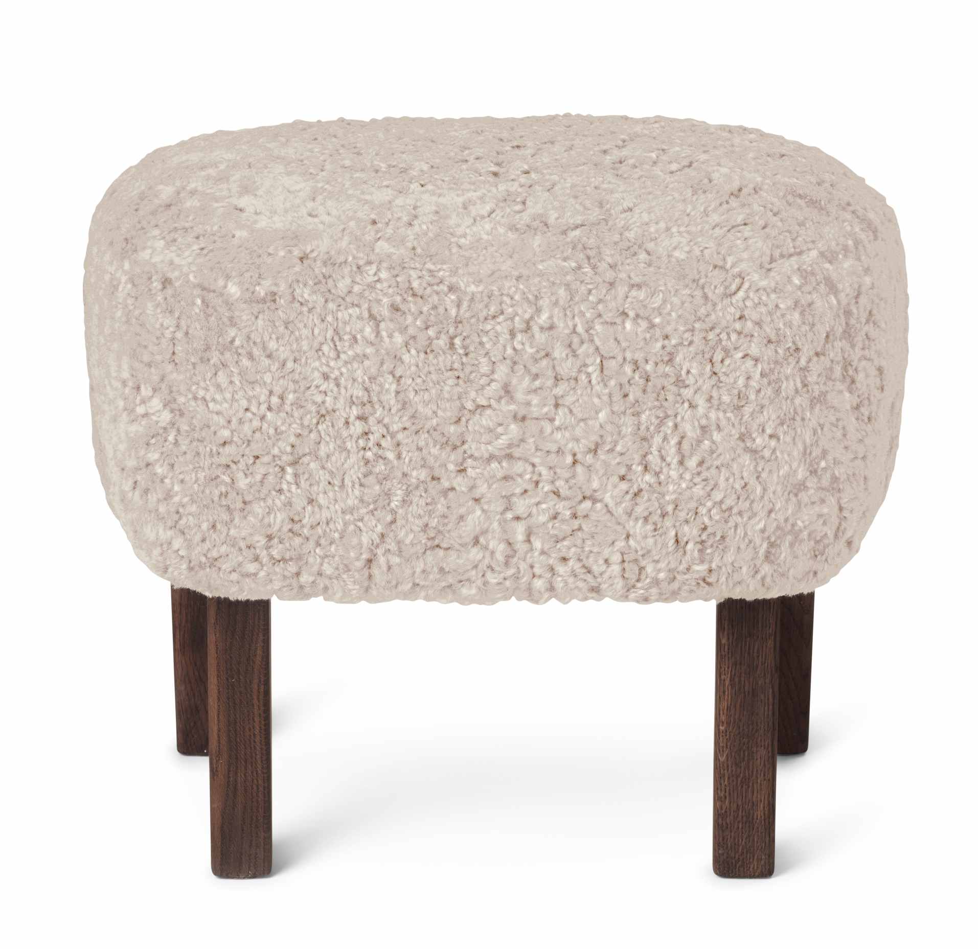 Beiger Ingeborg Ottoman von Audo mit weichem Schaffellbezug und dunklen Holzbeinen. Hocker für Wohnzimmer.