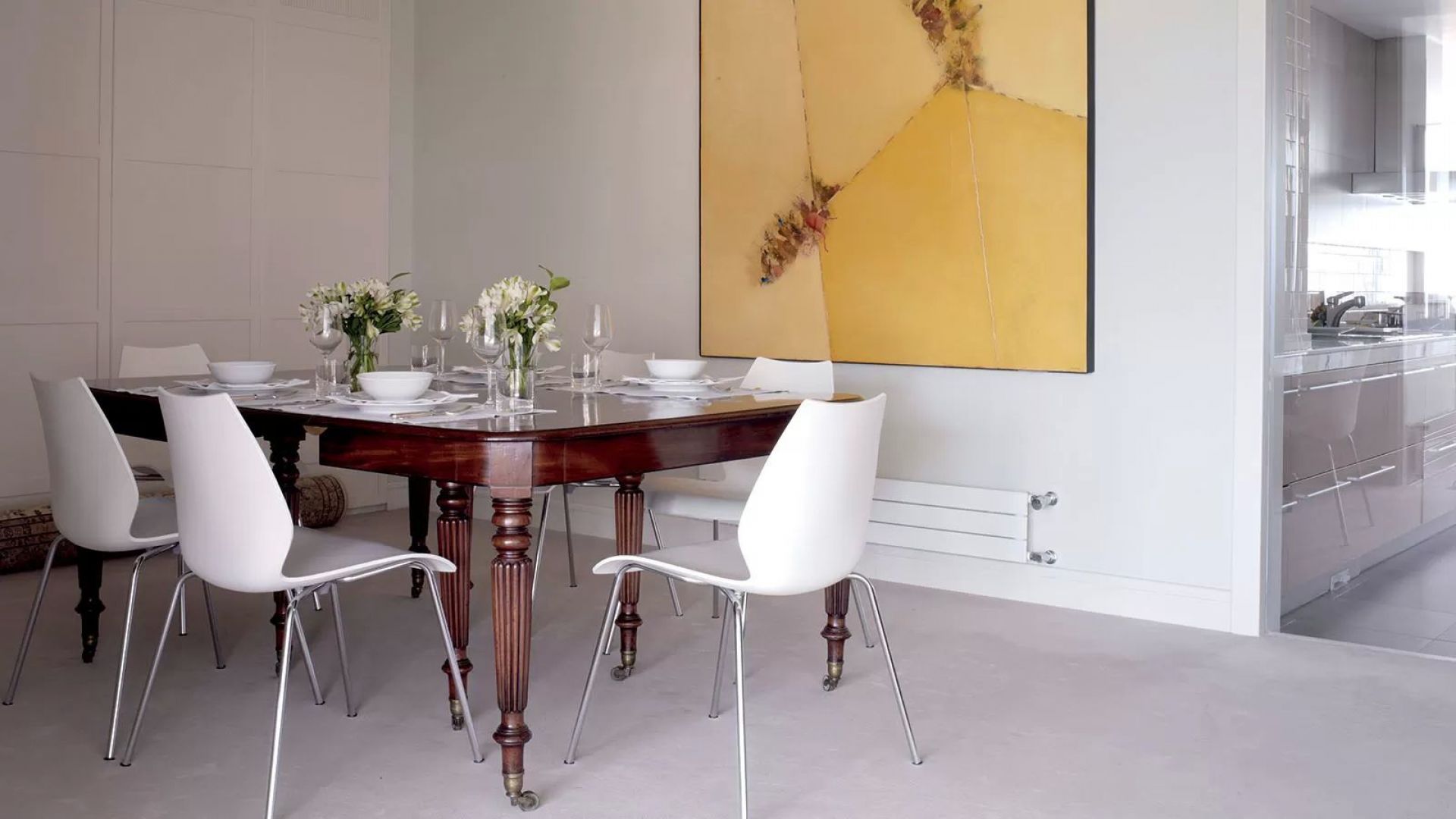 Esszimmer mit weißen Maui Stühlen ohne Armlehne von Kartell und Holztisch. Designermöbel für stilvolles Wohnen.