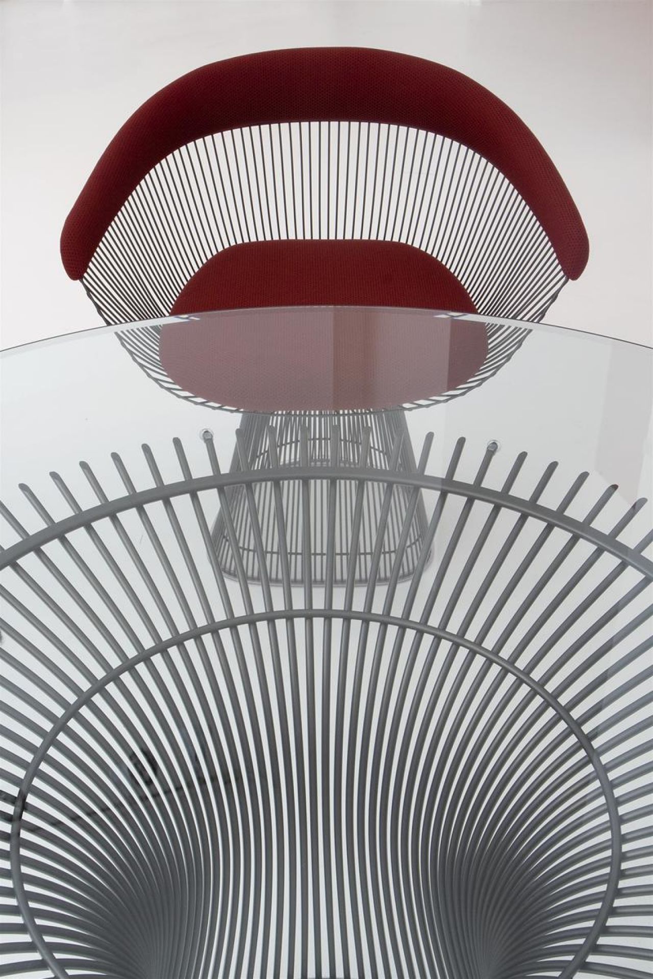 Detailaufnahme: Platner Sessel mit rotem Bezug und passendem Tisch mit Glasplatte. Designmöbel von Knoll International.