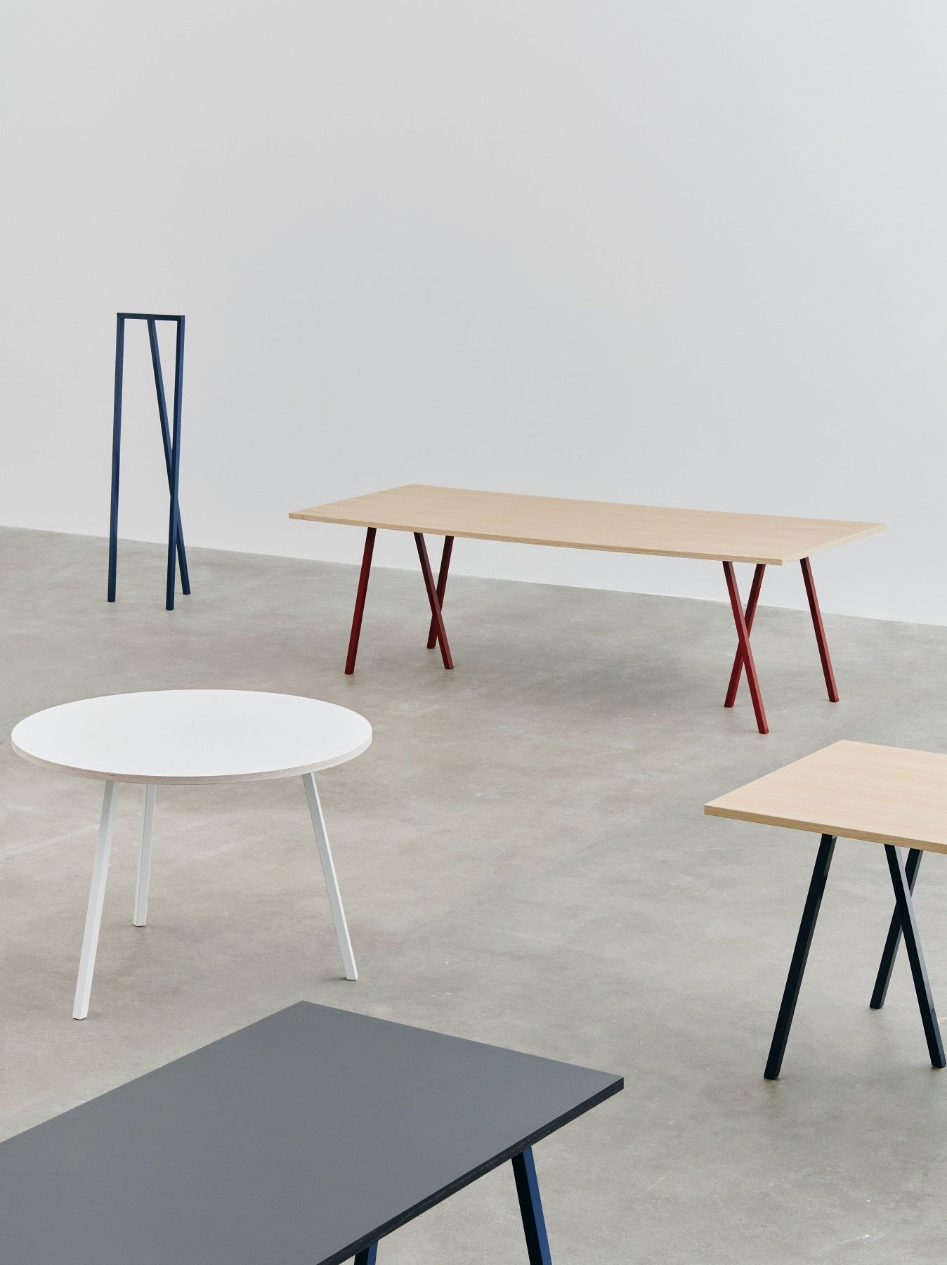 Verschiedene Hay Tische und die Loop Stand Hall Garderobe in Blau, minimalistisches Design für Flur und Wohnraum.