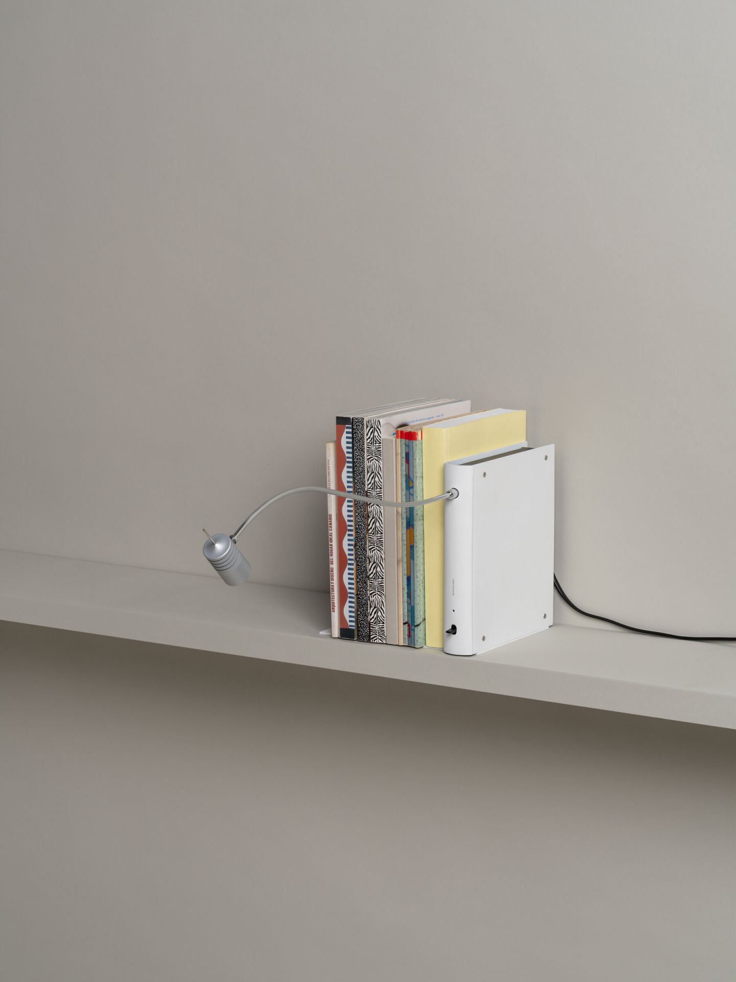 Bib Luz Tischleuchte von Santa & Cole in Off White als Buchstütze mit flexiblem Arm.