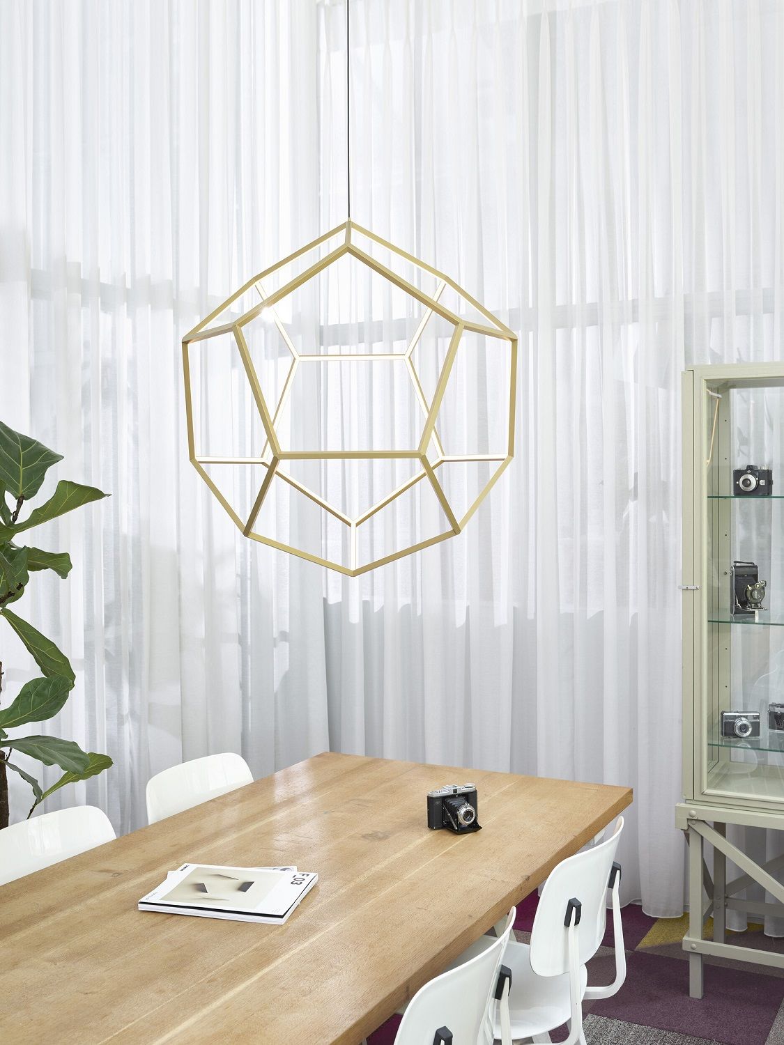 Dodeca Pendelleuchte Japth: Goldene, geometrische Hängelampe über Esstisch in modernem Interieur.