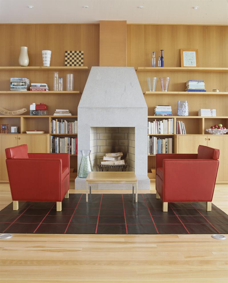 Roter Krefeld Sessel von Knoll International vor einem Kamin mit Bücherregal. Designermöbel.