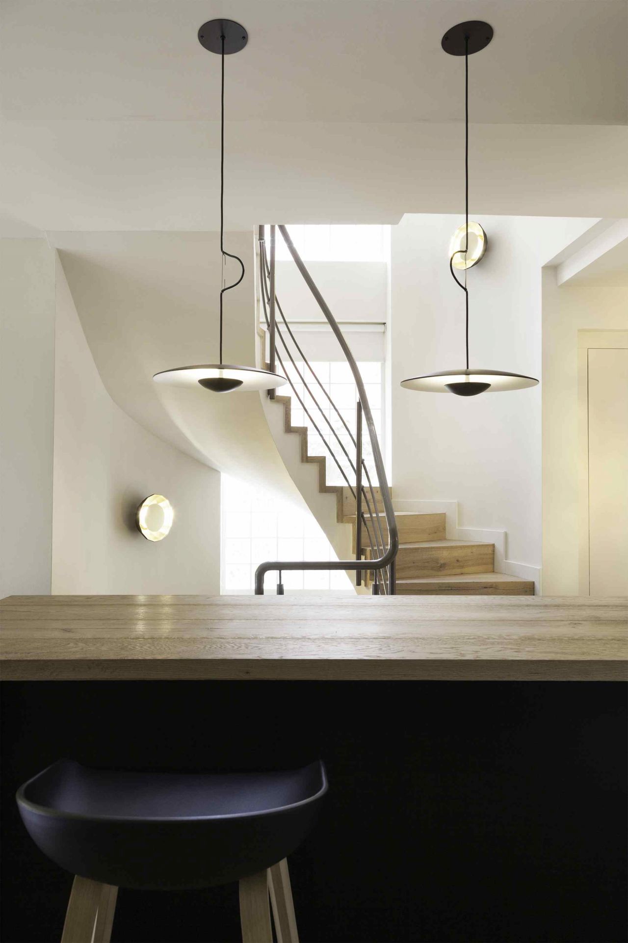 Zwei Ginger Pendelleuchten von Marset aus Eiche beleuchten einen modernen Wohnraum.