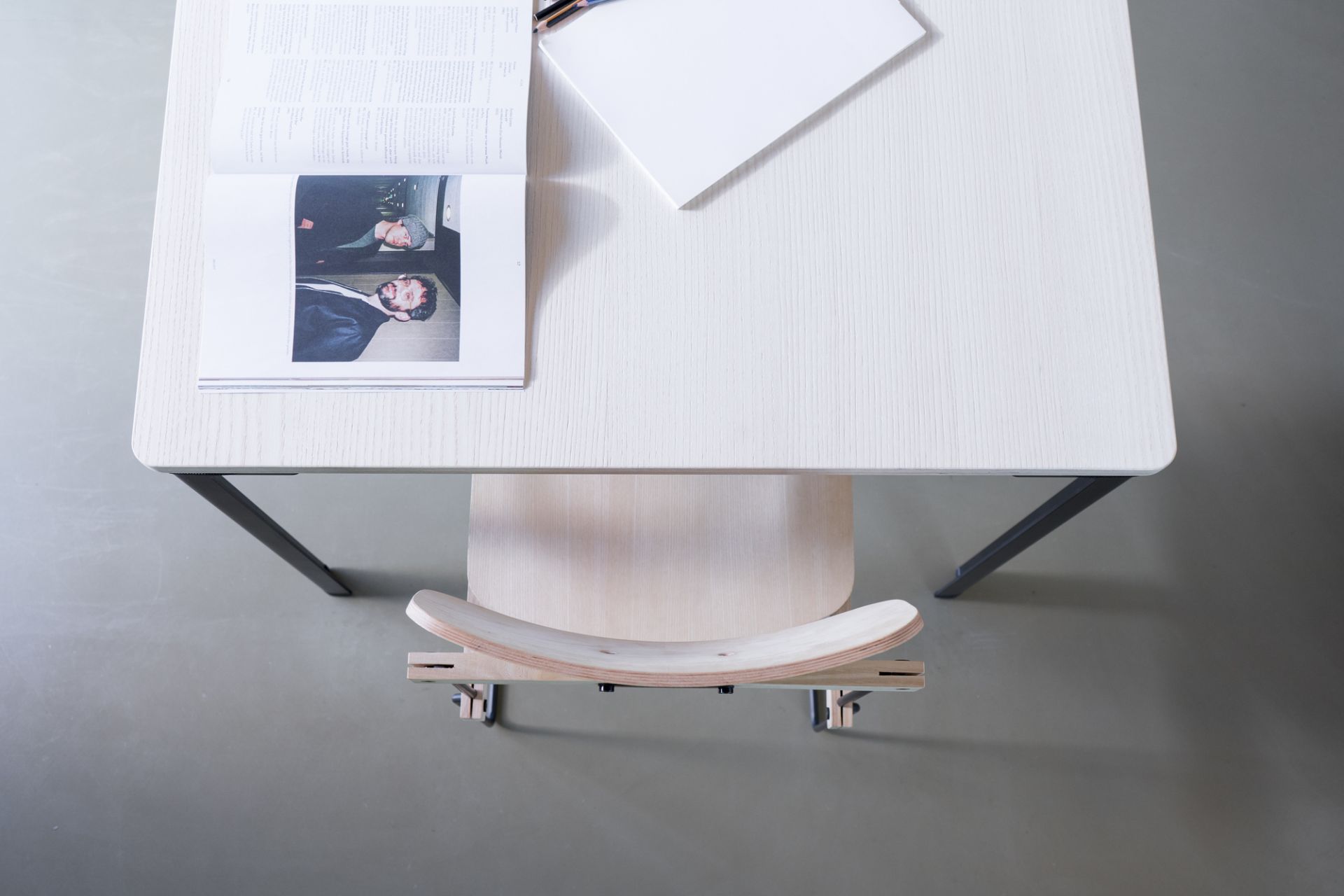 Ansicht von oben: Heller Bruto Stuhl ohne Armlehne von Nils Holger Moormann unter einem Schreibtisch.