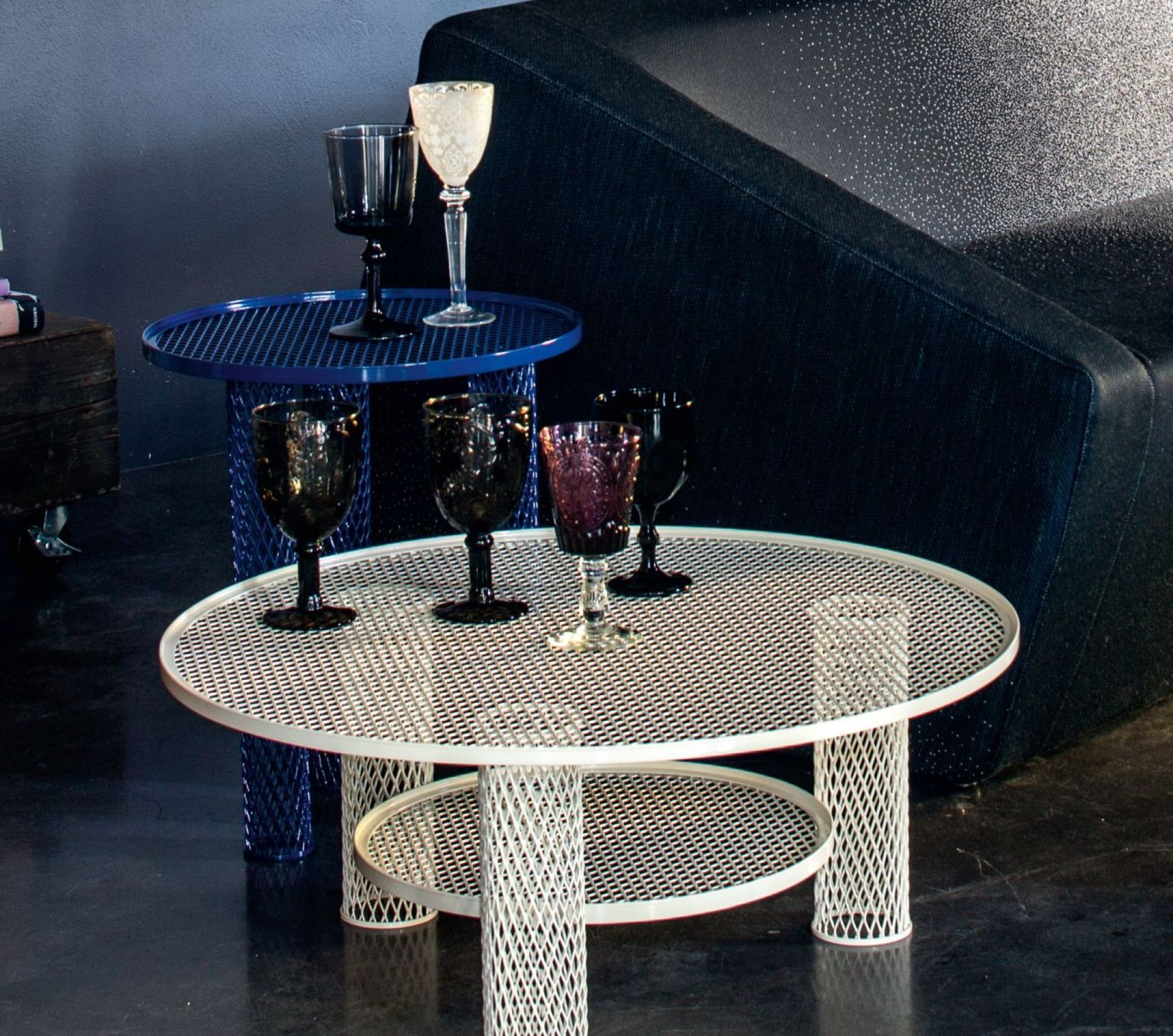Detailaufnahme: Zwei Net Beistelltische von Moroso, einer in Tinte, mit Gläsern dekoriert.