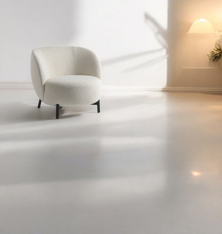 Lunam Sessel von Kartell, cremefarbener Bouclé-Sessel mit schwarzen Beinen vor hellem Hintergrund. Design Möbel.