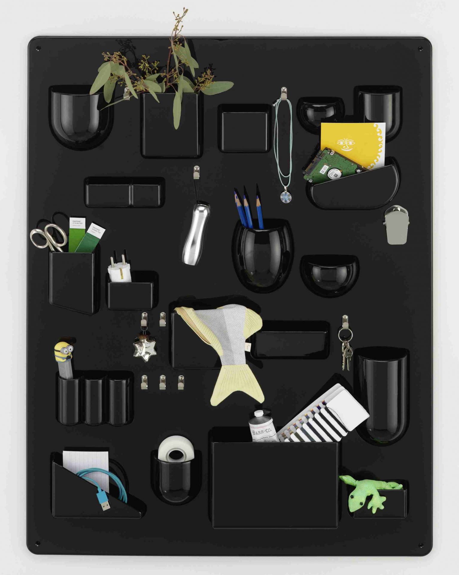 Schwarzes Uten.Silo Wand-Ordnungssystem von Vitra, gefüllt mit Büroartikeln, Pflanzen und Dekoration, zur stilvollen Aufbewahrung von Alltagsgegenständen.